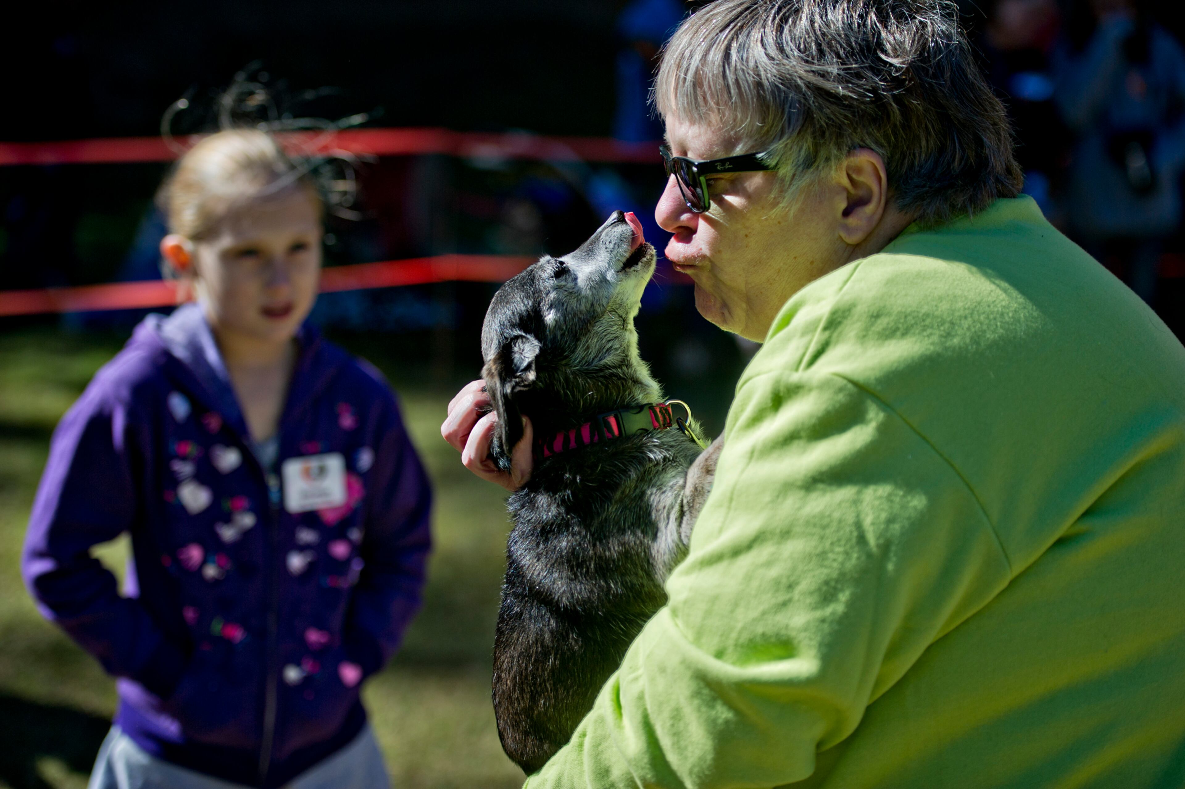 Kim Boehm (right) is licked by her dachshund Sasha as Riley Samples counts in the kissing contest during Howl-O-Weenie at Liane Levetan Park at Brook Run in Dunwoody on Saturday, October 4, 2014. The event celebrated everything dachshund with howling, kissing and costume contests, hot dogs and other competitions all to benefit DREAM Dachshund Rescue.