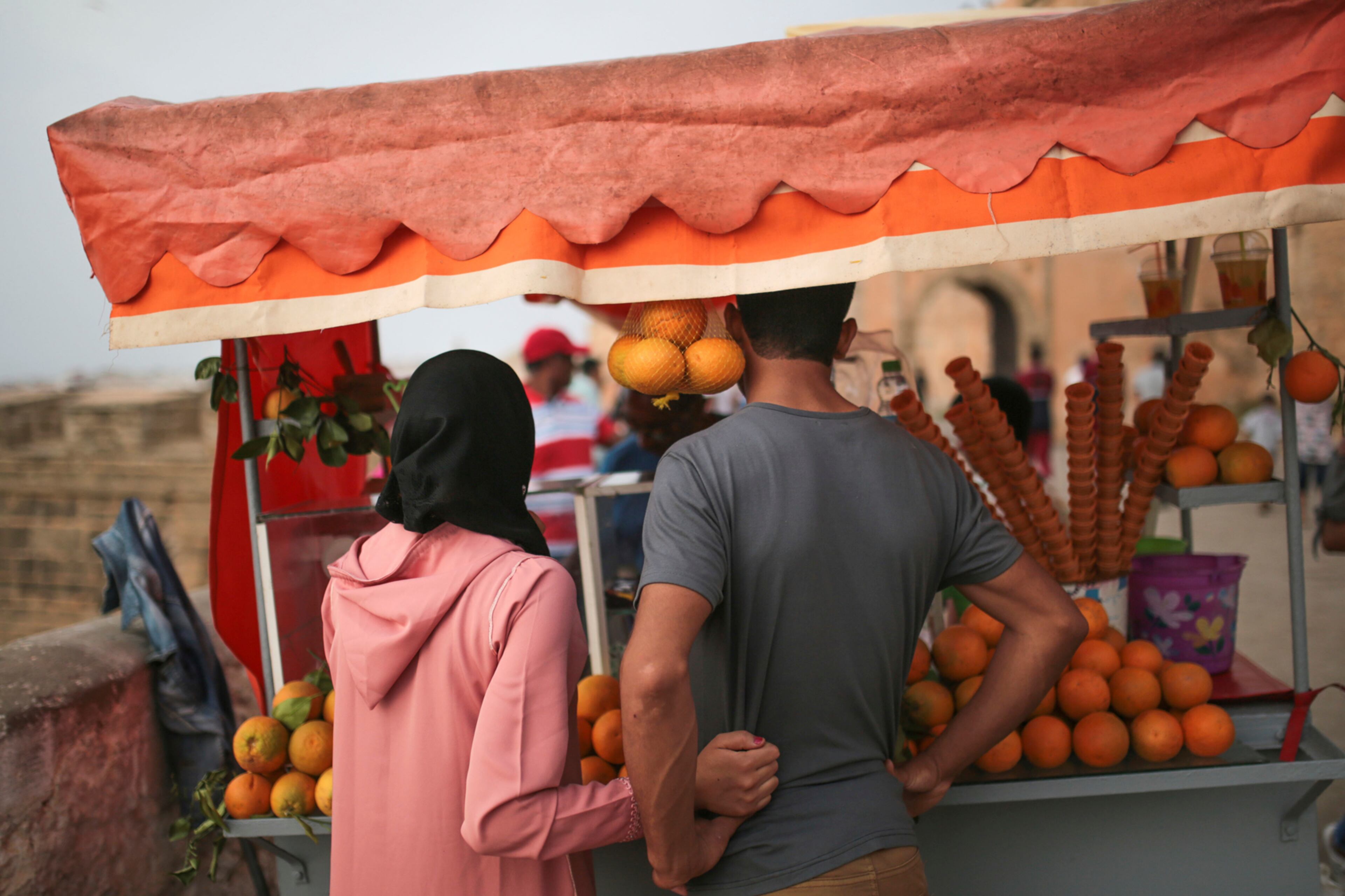 A couple purchases orange juice at a cart during Eid al-Fitr holiday in Rabat, Morocco, Monday, June 26, 2017. Eid al-Fitr marks the end of the Muslims' holy fasting month of Ramadan. (AP Photo/Mosa'ab Elshamy)