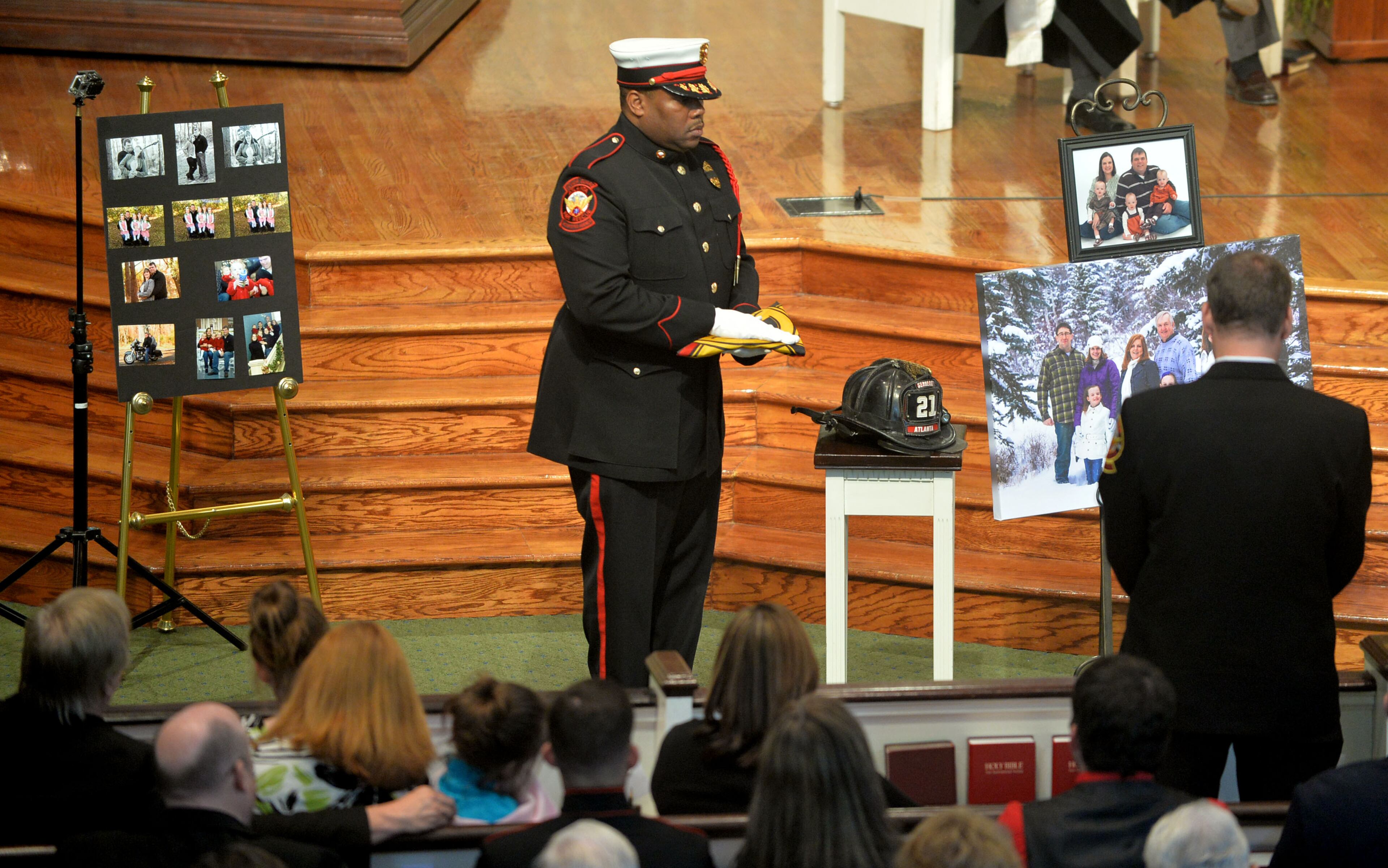 AFR Honor Guard Capt. William A. Pearson Jr holds the department flag near Sgt Guinn's helmet.