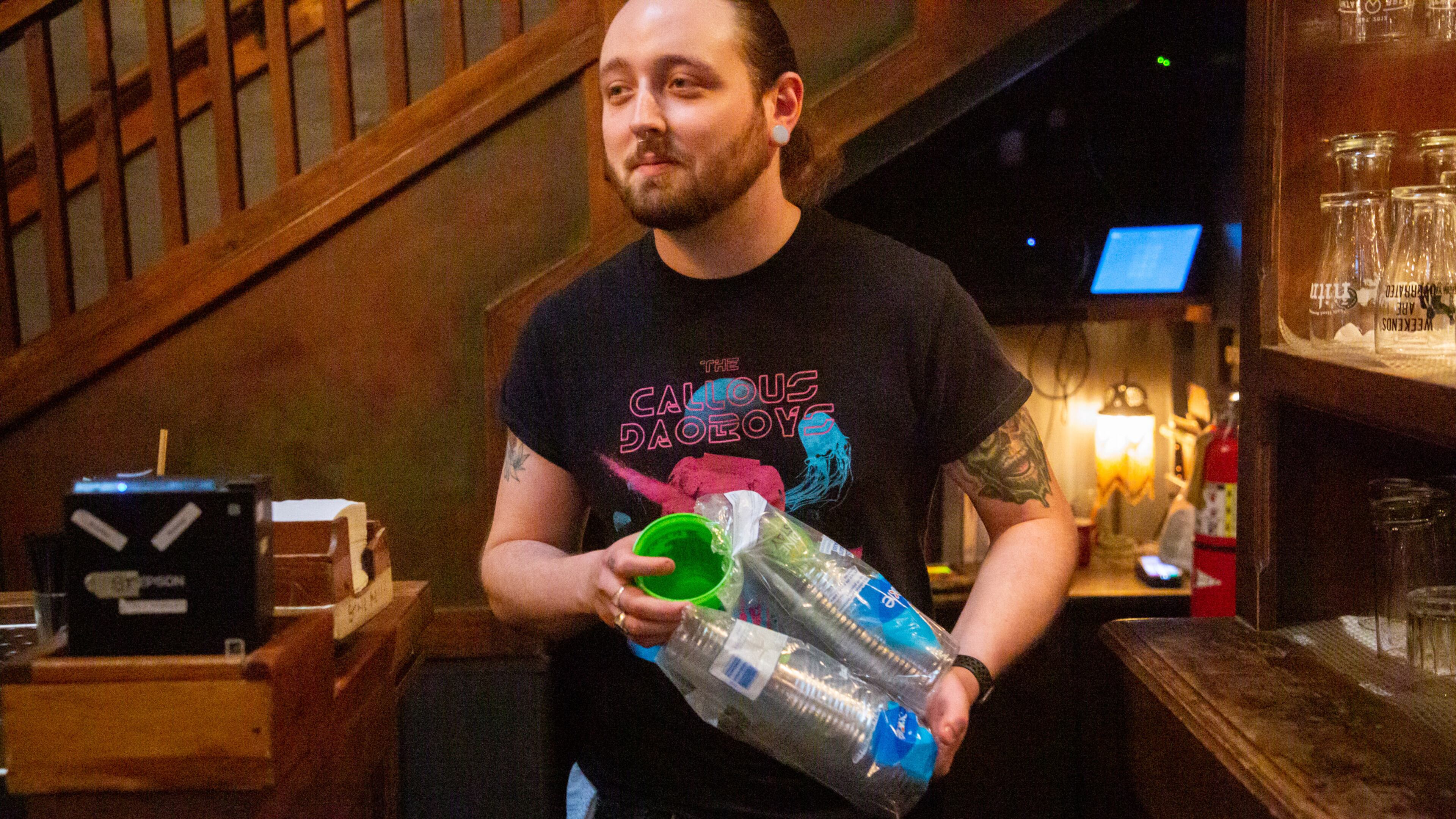 Brickhouse Pub bartender Trevor Cannon restocks the new to-go cups in Decatur Friday, December 10, 2021. STEVE SCHAEFER FOR THE ATLANTA JOURNAL-CONSTITUTION