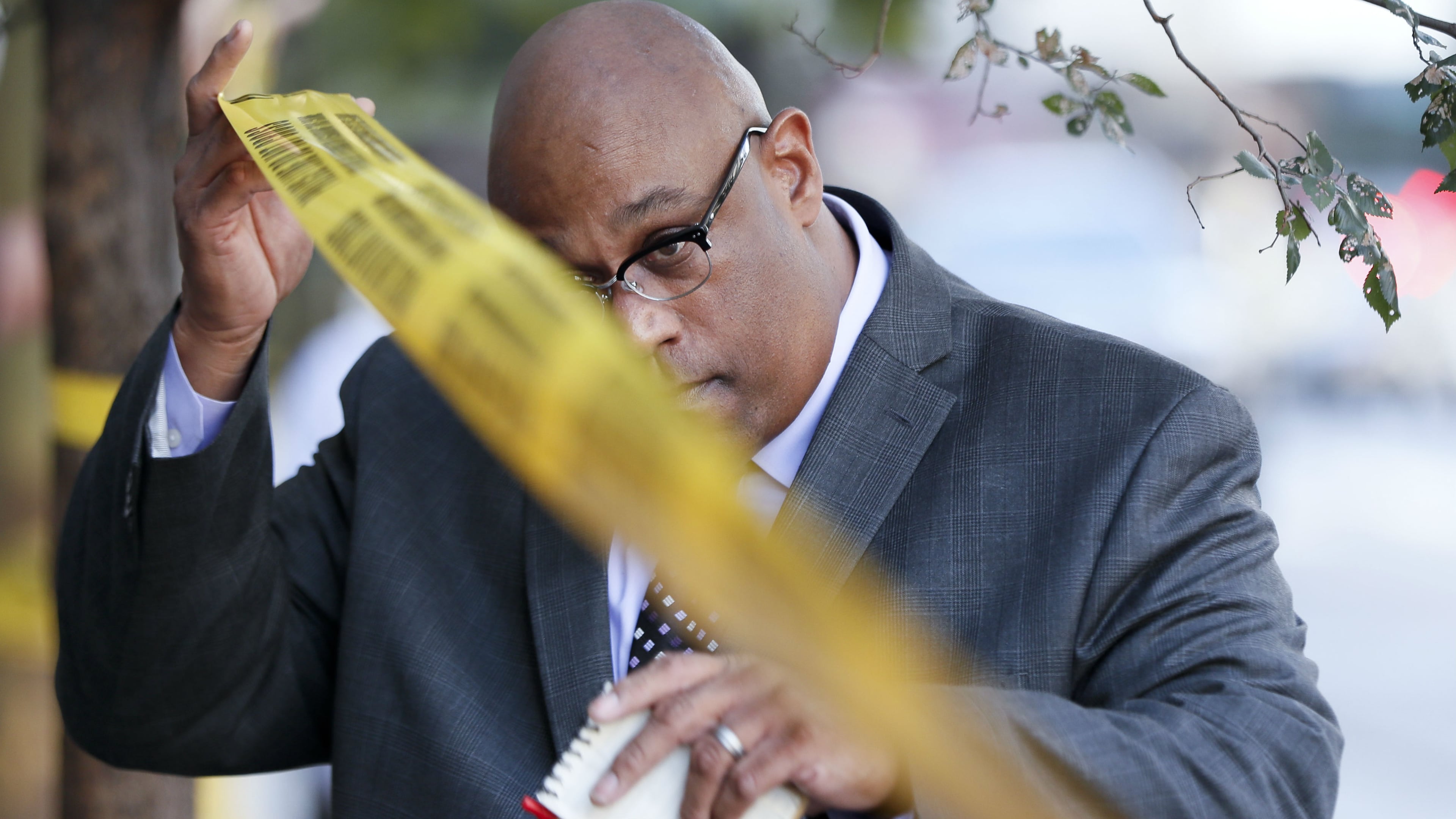 Cincinnati Police Chief Eliot Isaac ducks under police tape at the scene of a shooting Sept. 6, 2018, in downtown Cincinnati. Isaac announced Thursday, Dec. 20, 2018, that a 28-year veteran officer had been found dead inside a vehicle in the city's Eden Park. Dr. Lakshmi Sammarco, the Hamilton County coroner, said at the scene that the officer's death was not from natural causes.