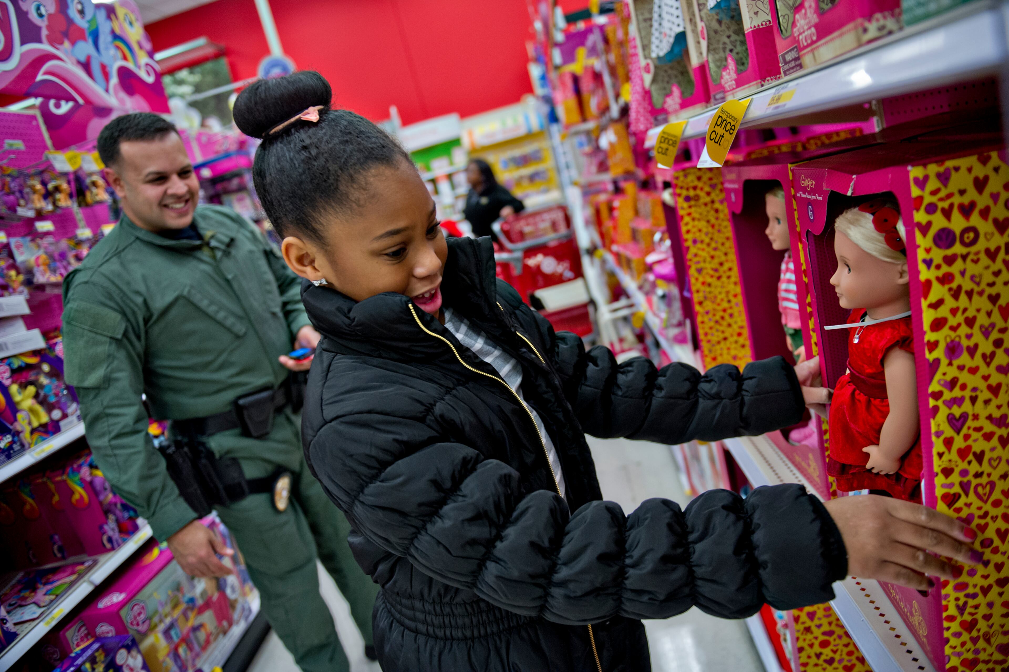 December 13, 2014 Atlanta - Soleil Jarrett (right) picks out a doll as she shops with Brookhaven Police Det. Johnny Alemany during the first annual Brookhaven Police Shop with a Badge event at the Target off of North Druid Hills in Atlanta on Saturday, December 13, 2014. Officers from the Brookhaven Police Department teamed up with Target and the Brookhaven Boys $ Girls Club to help 41 children buy presents for Christmas. Each child received a $200 gift card to help buy presents for family members. JONATHAN PHILLIPS / SPECIAL