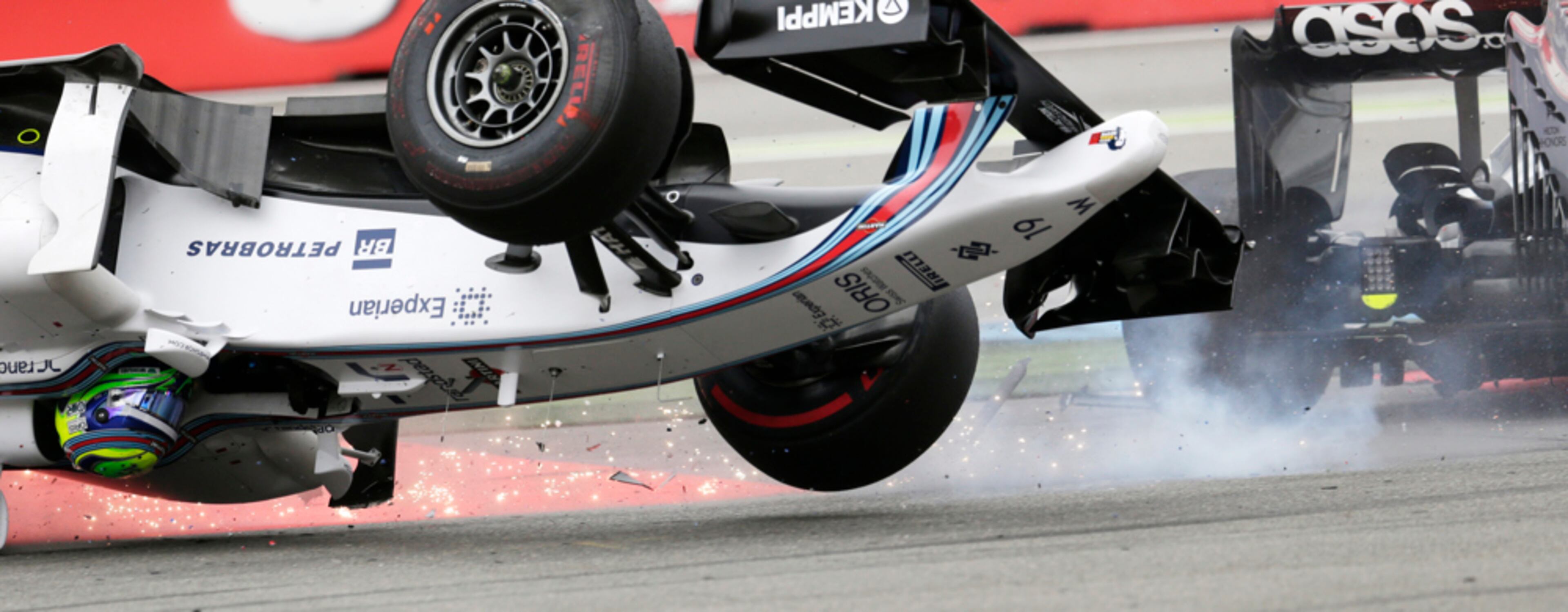HOPE THAT HELMET IS ON TIGHT--Williams driver Felipe Massa of Brazil crashes in the first curve of the German Formula One Grand Prix in Hockenheim, Germany, Sunday, July 20, 2014. (AP Photo/Petr David Josek)