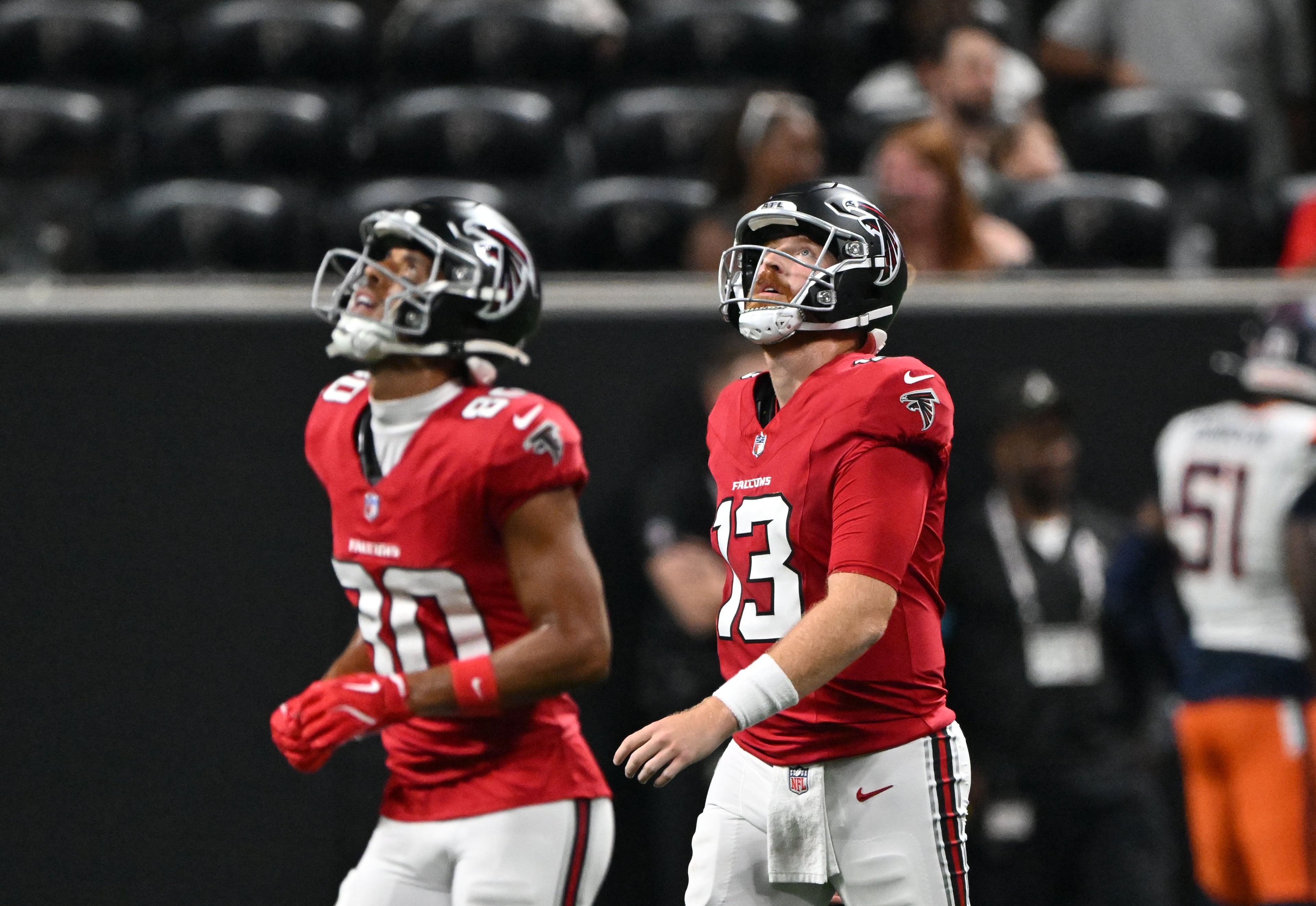 Falcons wide receiver Dylan Drummond (left) and quarterback Cooper Rush walk off the field after Broncos cornerback Jahdae Barron scores a touchdown after intercepting the ball during their preseason game at Mercedes-Benz Stadium on Friday, Aug. 14, 2026, in Atlanta. (Hyosub Shin/AJC)