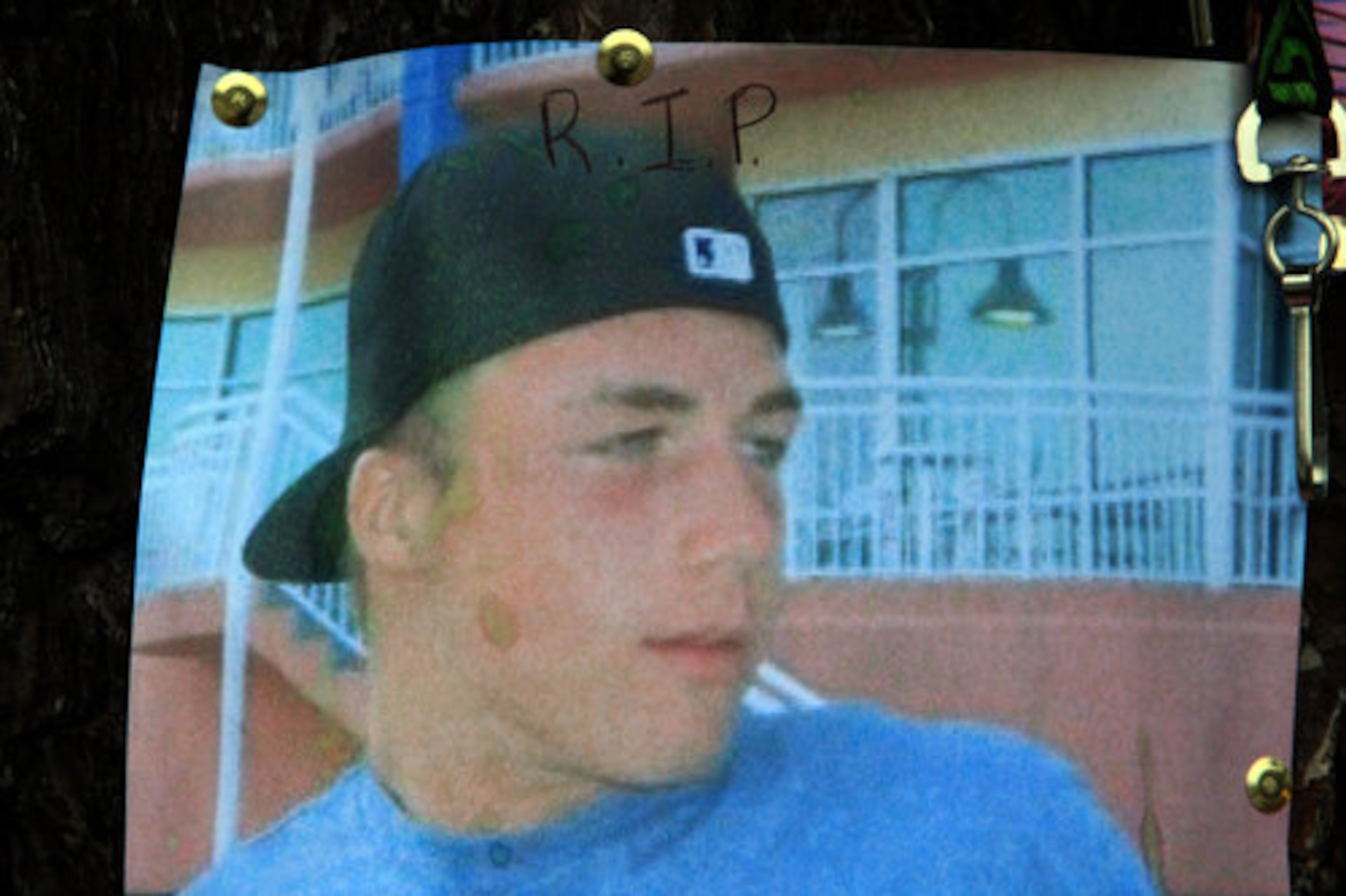 A photo of Garrett Reed was attached to a tree as part of the roadside memorial.