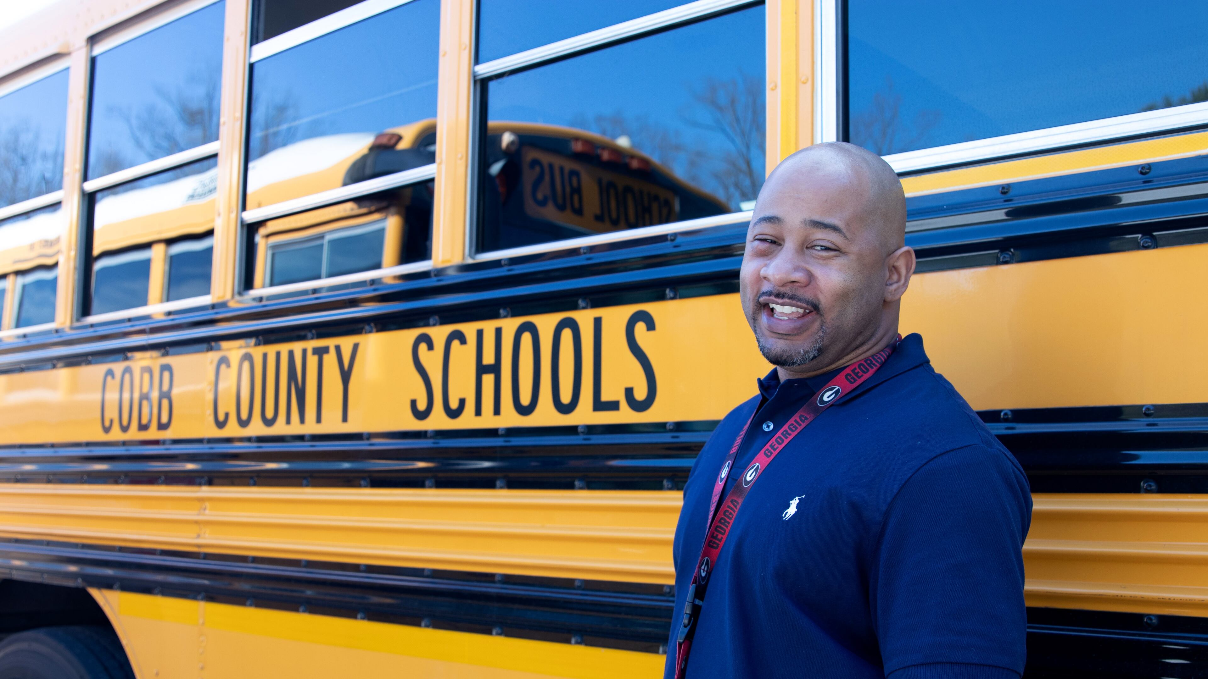 Ricky Cooper, a Cobb County School District bus driver, helped a woman escape a vehicle after it overturned in a ditch.