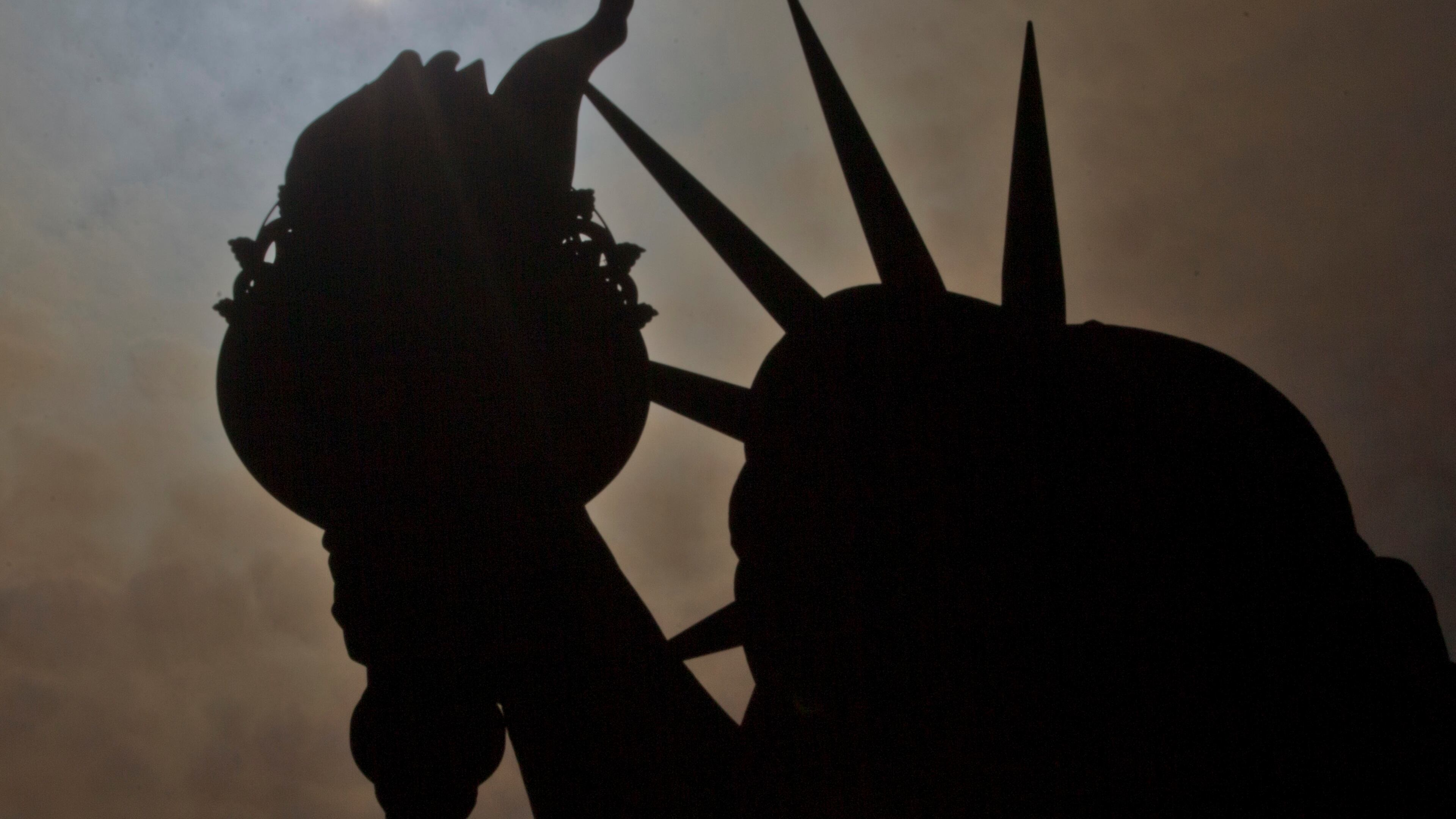 A partial solar eclipse is seen near the Statue of Liberty on Liberty Island in New York last August. AP/Seth Wenig