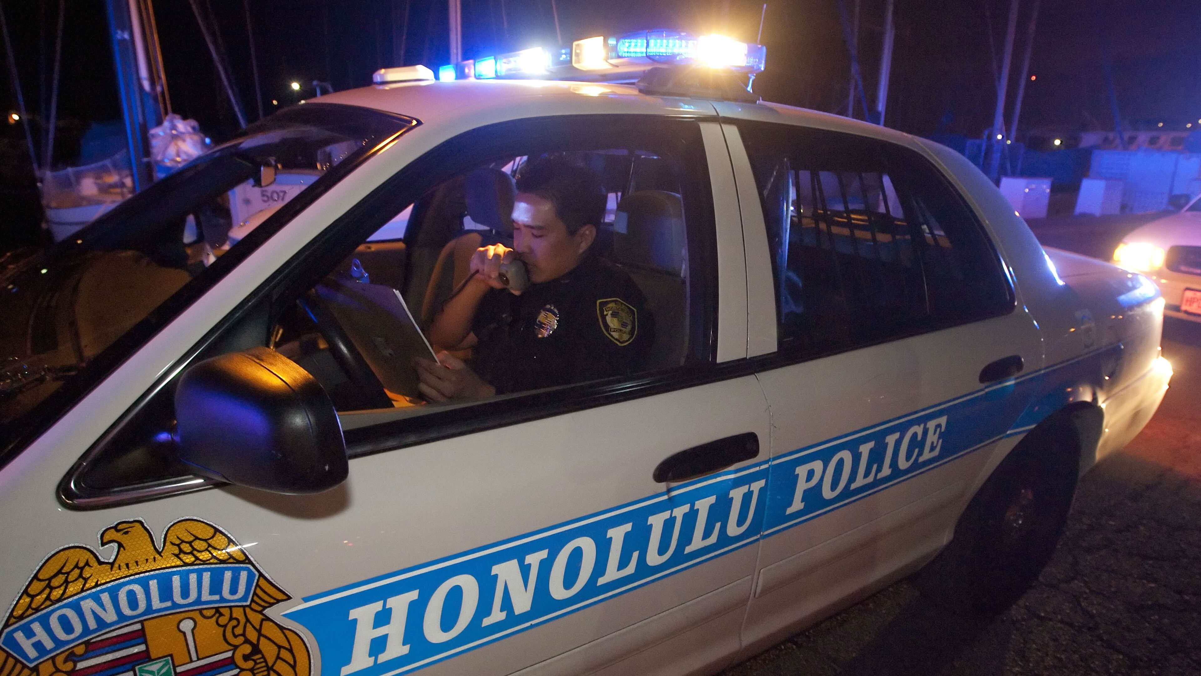 A Honolulu police officer talks into his public address system in this March 2011 photo. (AP Photo/Eugene Tanner)