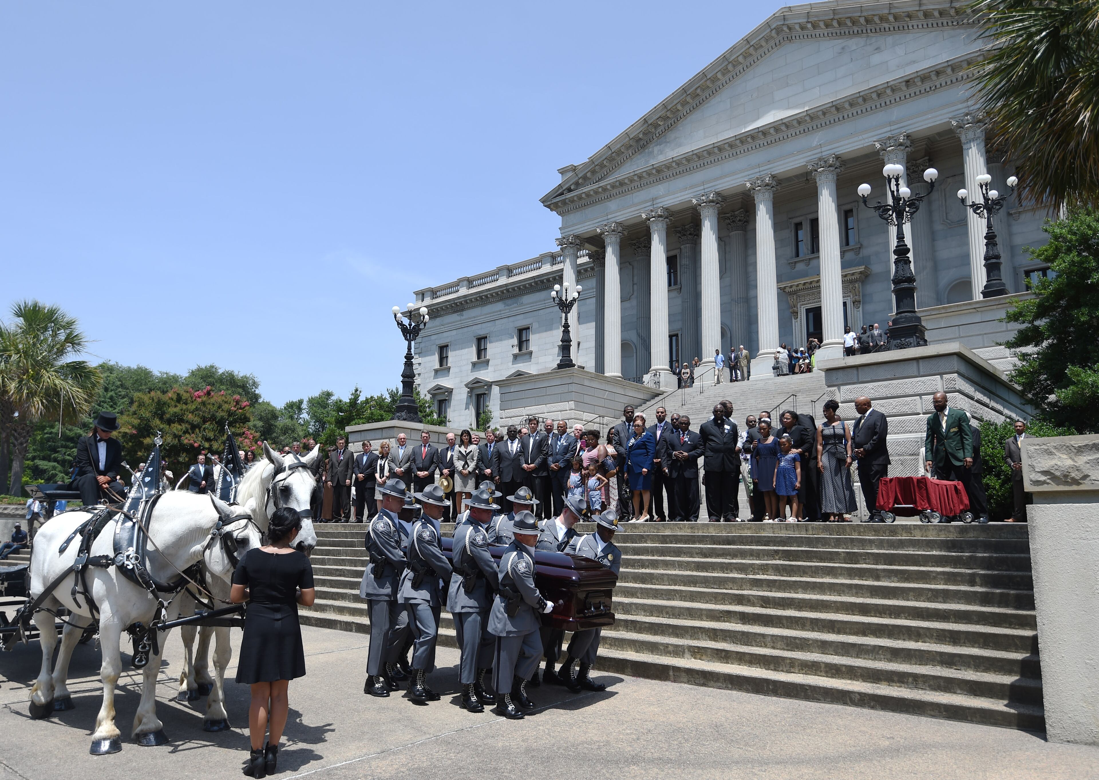 A South Carolina Highway Patrol honor guard carries Sen. Clementa Pinckney's casket to the Statehouse, Wednesday, June 24, 2015, in Columbia, S.C. Pinckney's open coffin was being put on display under the dome where he served the state for nearly 20 years. Pinckney was one of those killed in a mass shooting at the Emanuel AME Church in Charleston. (AP Photo/Rainier Ehrhardt)