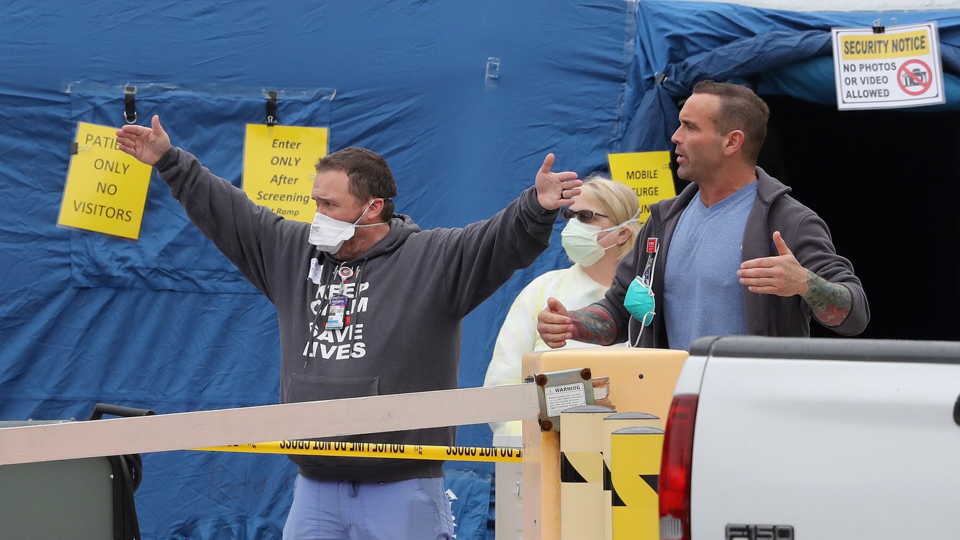 Medical workers give instructions at the entrance to the mobile surge unit tent outside the emergency entrance at WellStar Kennestone Hospital. Curtis Compton ccompton@ajc.com