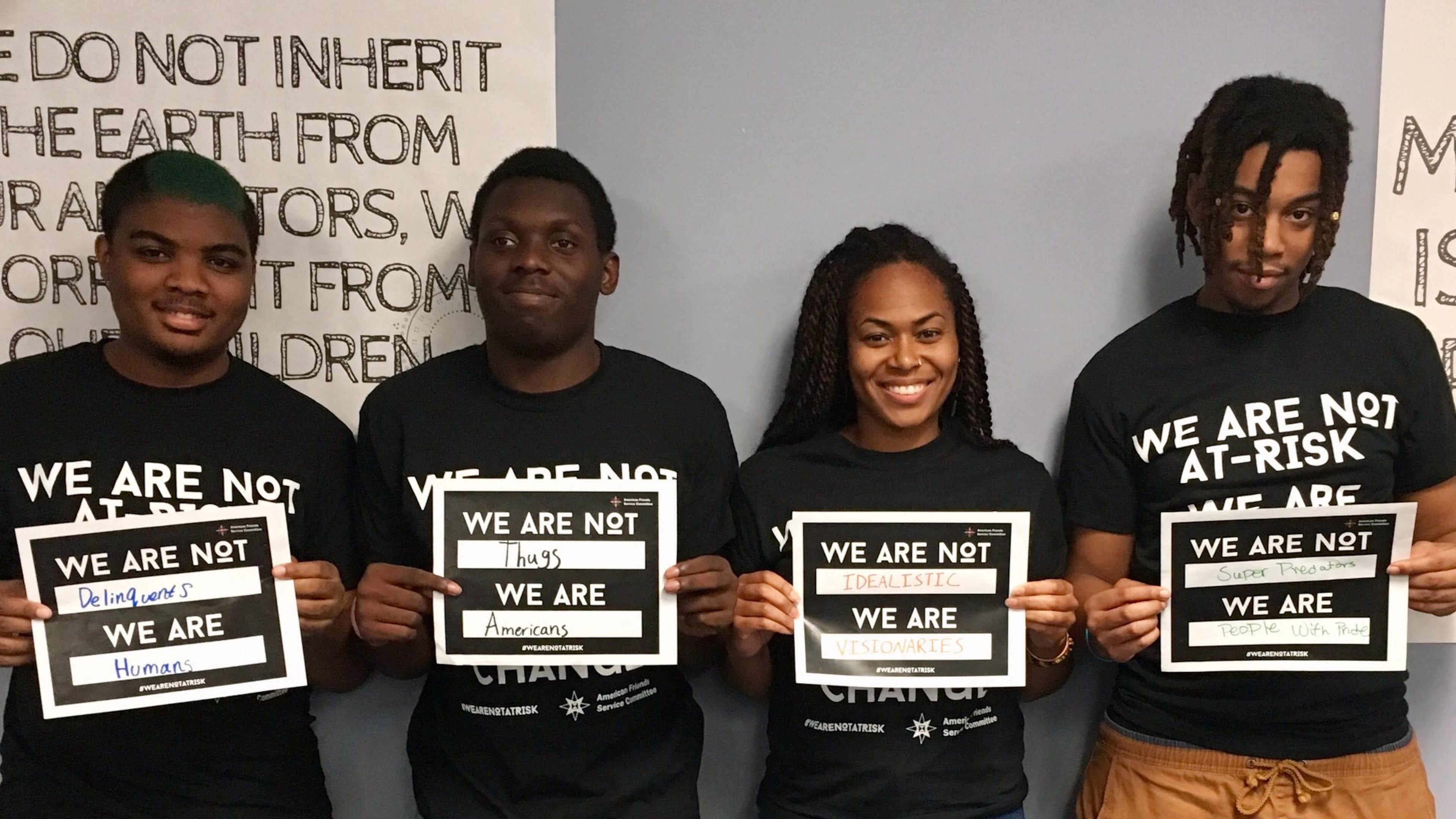 Quavontaye Scott, Marquel Johnson, Foluke Nunn and Brenquavious Johnson hold signs they created for the We Are Not At-Risk social media campaign that seeks to end the use of negative language to describe minority kids. CONTRIBUTED