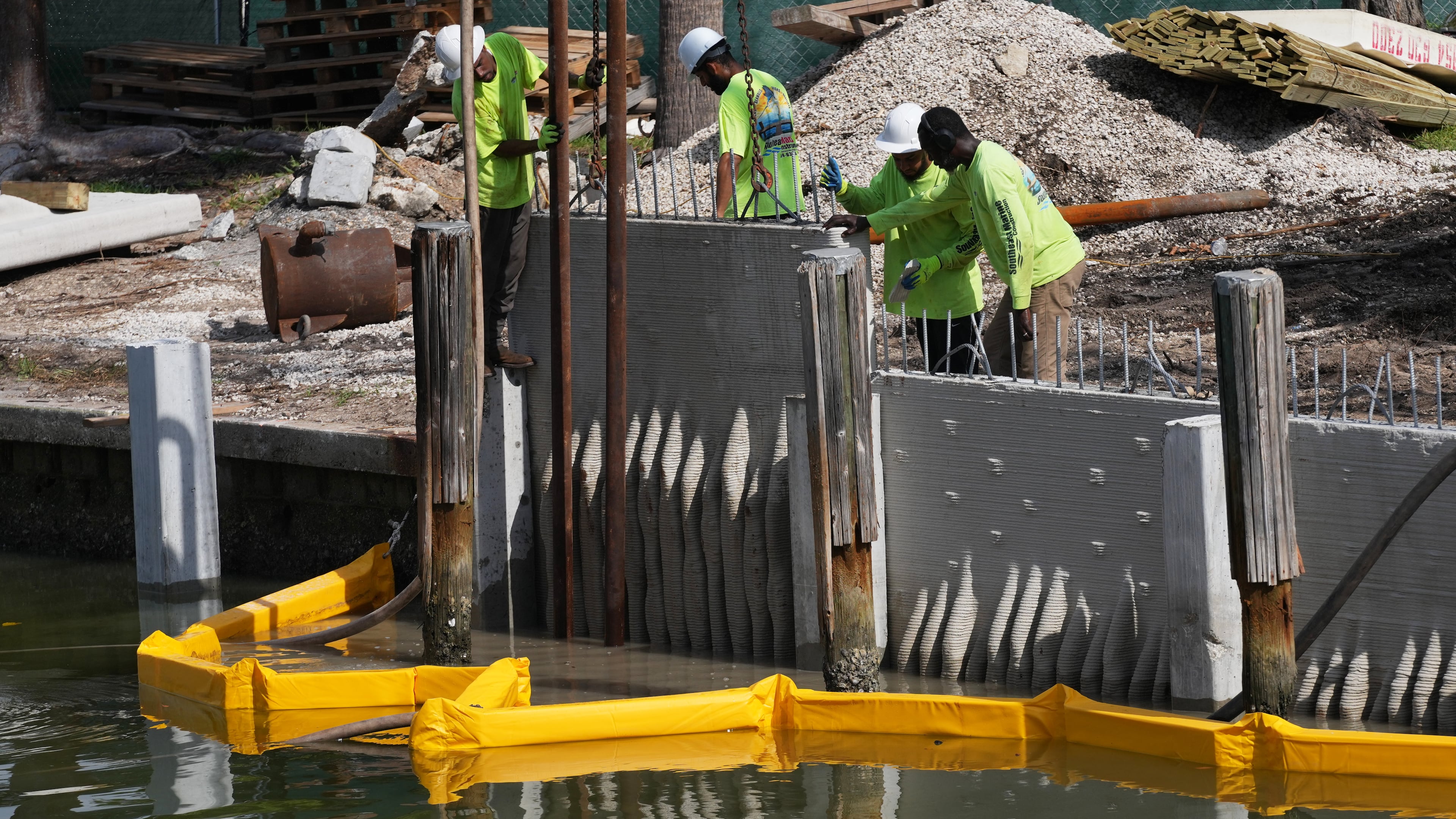 Workers install a 3D-printed living seawall manufactured by Kind Designs at the Church by the Sea, Tuesday, Aug. 4, 2026, in Fort Lauderdale, Fla. (AP Photo/Lynne Sladky)