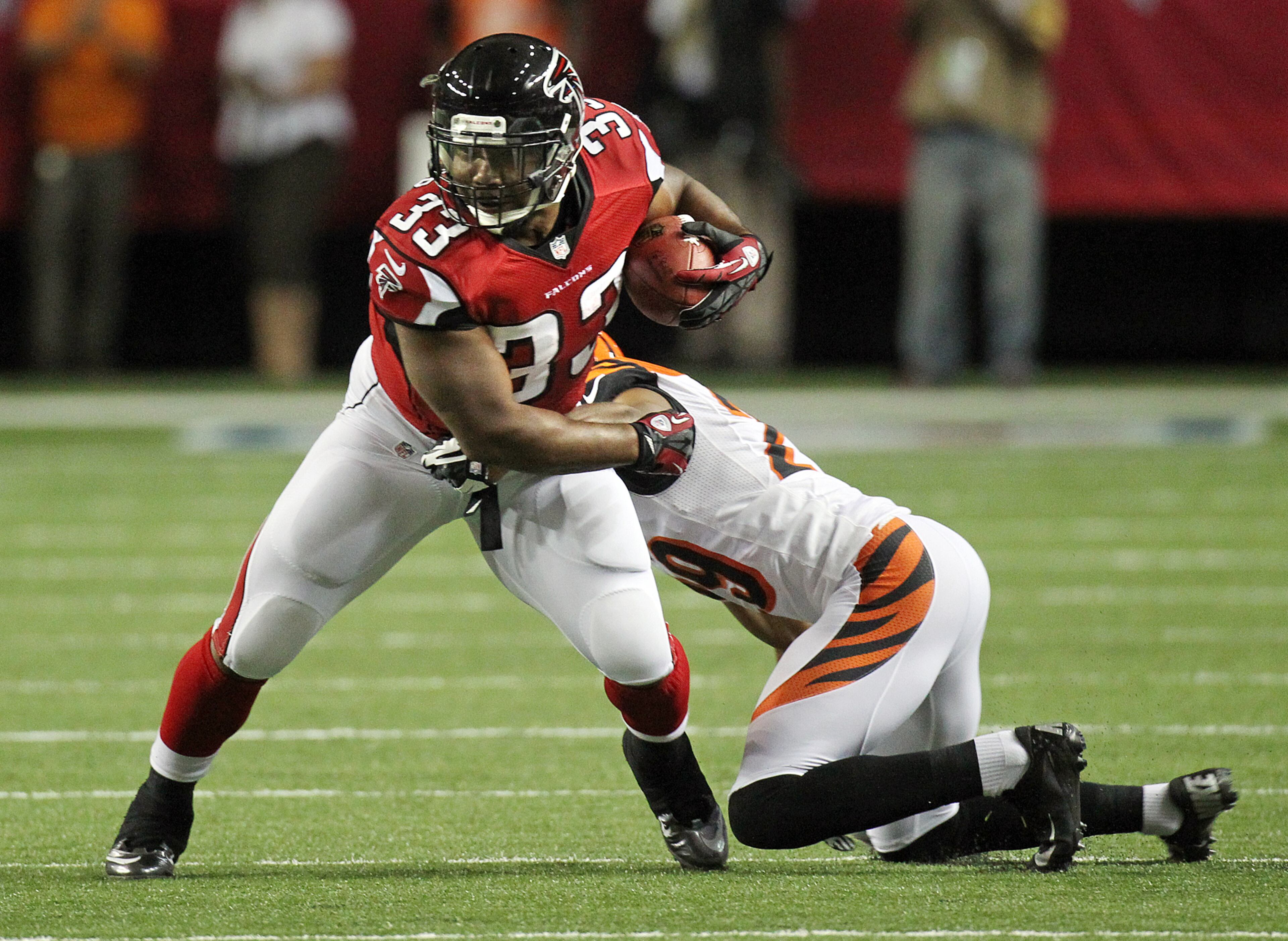 081612 ATLANTA: Bengals cornerback Leon Hall slows up Falcons running back Michael Turner until other defenders can arrive to hold him to short yardage in the first half at the Georgia Dome in Atlanta on Thursday, August 16, 2012. CURTIS COMPTON / CCOMPTON@AJC.COM