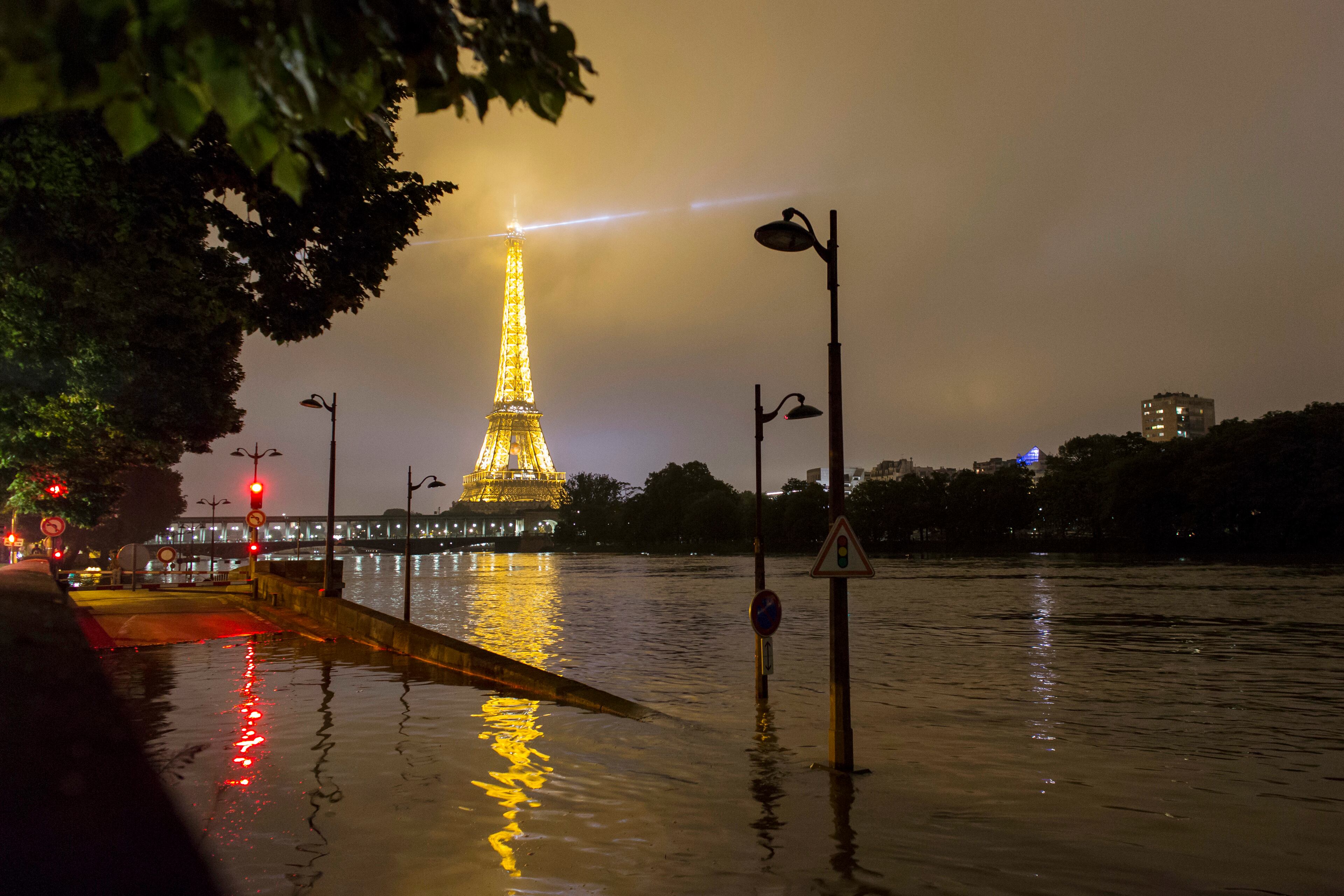 A traffic sign stands on the flooded banks of the Seine river near the Eiffel Tower in Paris, Friday, June 3, 2016. The swollen Seine River kept rising Friday, spilling into Paris streets and forcing one landmark after another to shut down as it surged to its highest levels in nearly 35 years. Across the city, museums, parks and cemeteries shut down as the city braced for evacuations. (AP Photo/Kamil Zihnioglu)