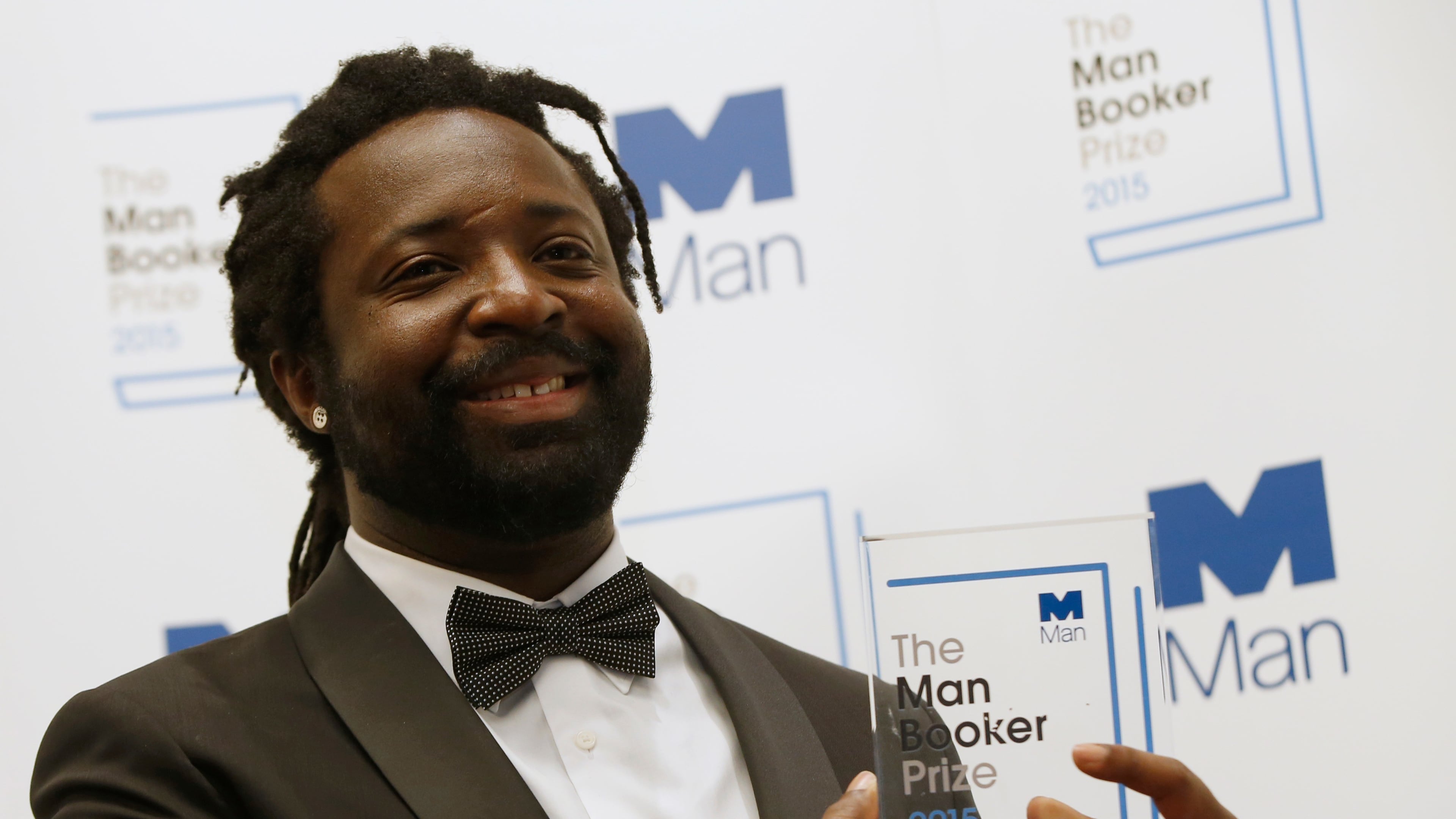 FILE - Marlon James poses with the award after his book 'A Brief History of Seven Killings' was named as winner of the 2015 Booker Prize 2015 for Fiction, following the award ceremony at the Guildhall in London, Tuesday, Oct. 13, 2015.(AP Photo/Alastair Grant, file)