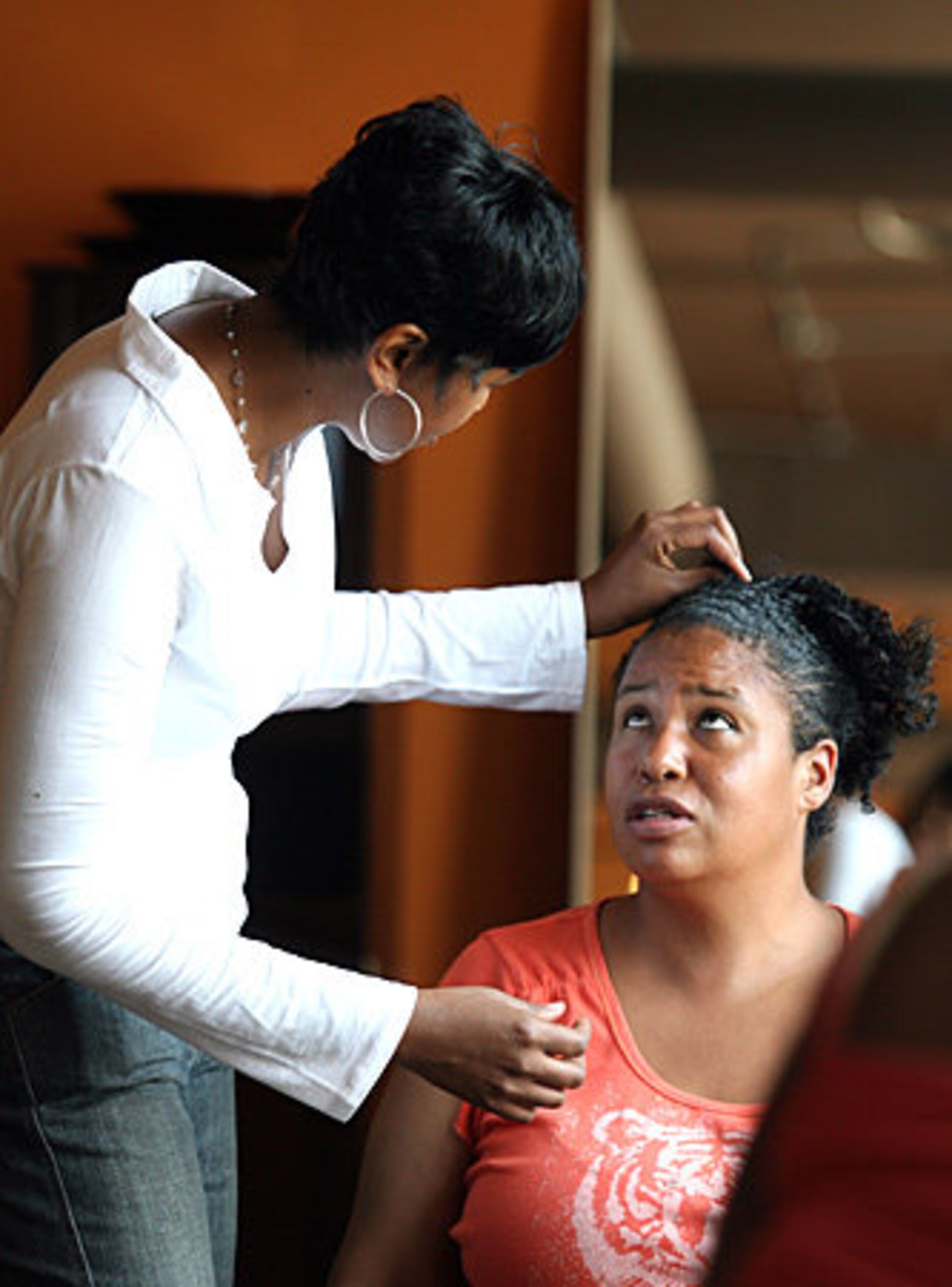 Co-owner and stylist Lateesha Aziz (left) talks with Jennifer Monahan about how she'd like her hair cut. Monahan called the experience a blessing and said the new 'do will "help me to be a little more confident looking for a job."