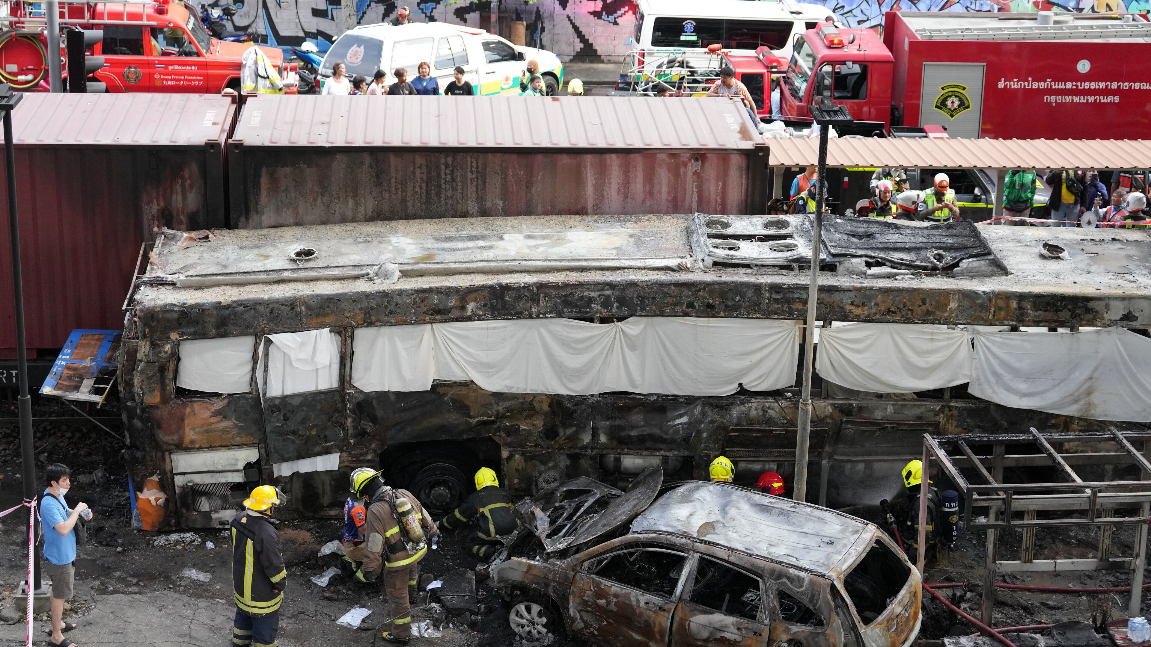 Rescuers work at a train crash site near an airport rail link station in Bangkok, Thailand, Saturday, May 16, 2026. (AP Photo/Sakchai Lalit)