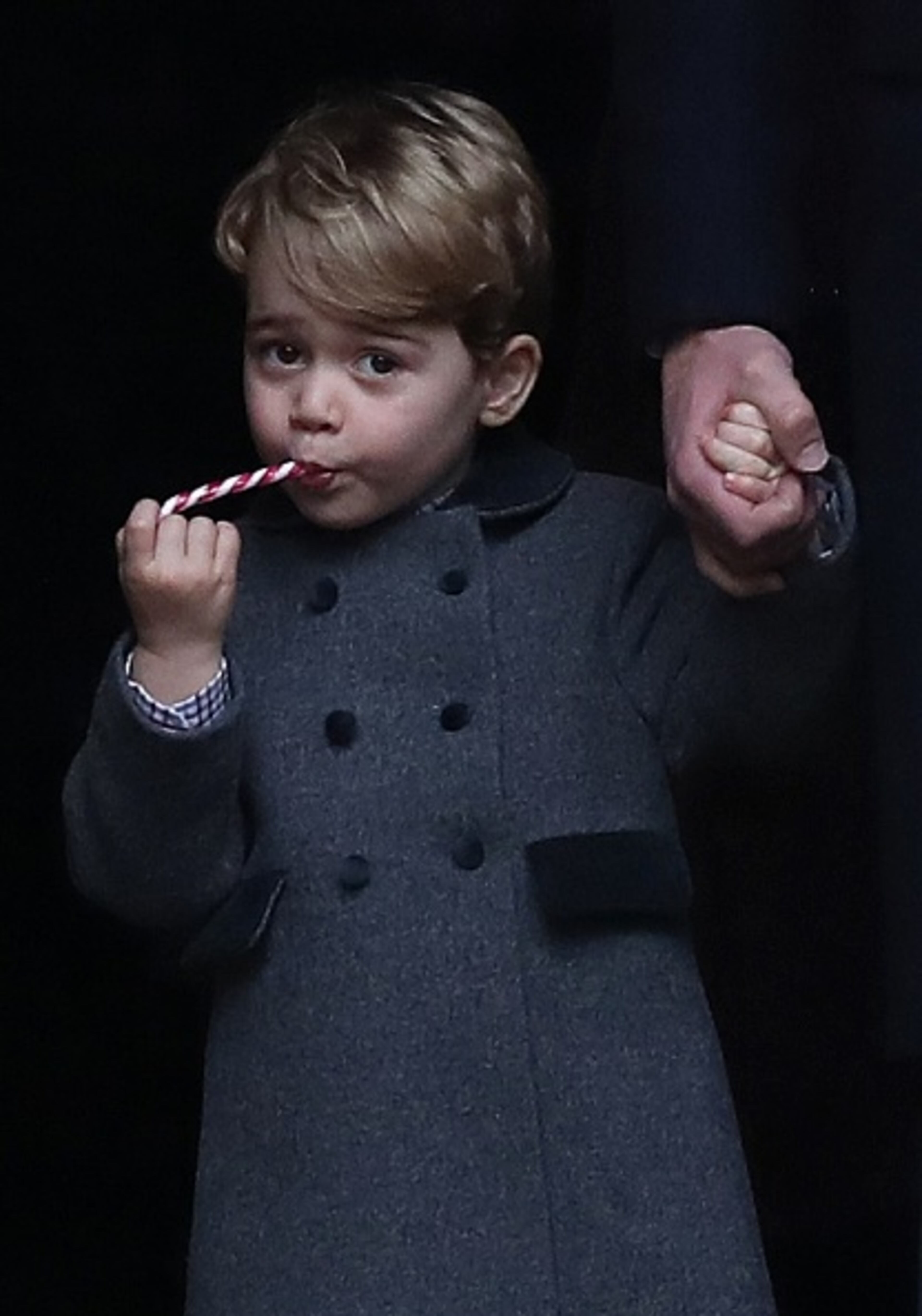 BUCKLEBURY, BERKSHIRE - DECEMBER 25: Prince George of Cambridge eats a sweet as he leave following the service at St Mark's Church on Christmas Day on December 25, 2016 in Bucklebury, Berkshire. (Photo by Andrew Matthews - WPA Pool/Getty Images)
