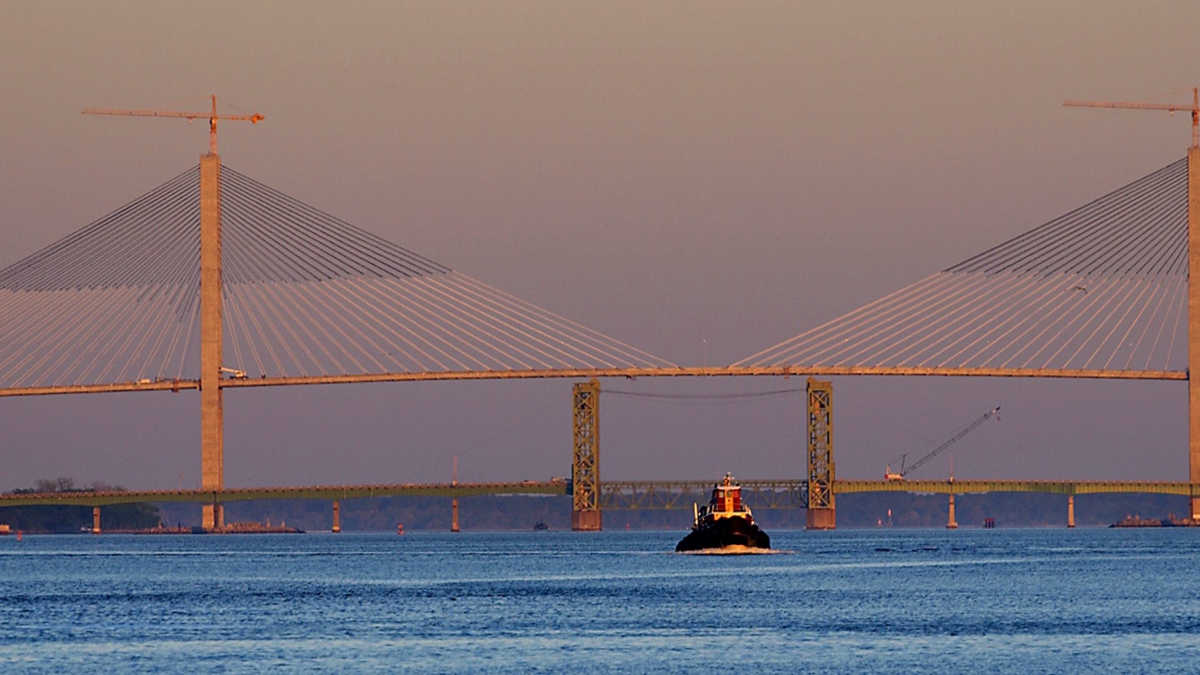 In this 2003 photo, a tugboat makes it's way to Colonel's Island to help take a cargo ship out to sea. In the background are the new and old Sidney Lanier bridges. The newest one spans the width of this photo, and is the largest bridge in Georgia, and one of the largest cable-stayed bridges in the world. The bridge will be dedicated April 7 after seven years of construction and a two-year delay in completion. (JOEY IVANSCO/AJC staff)