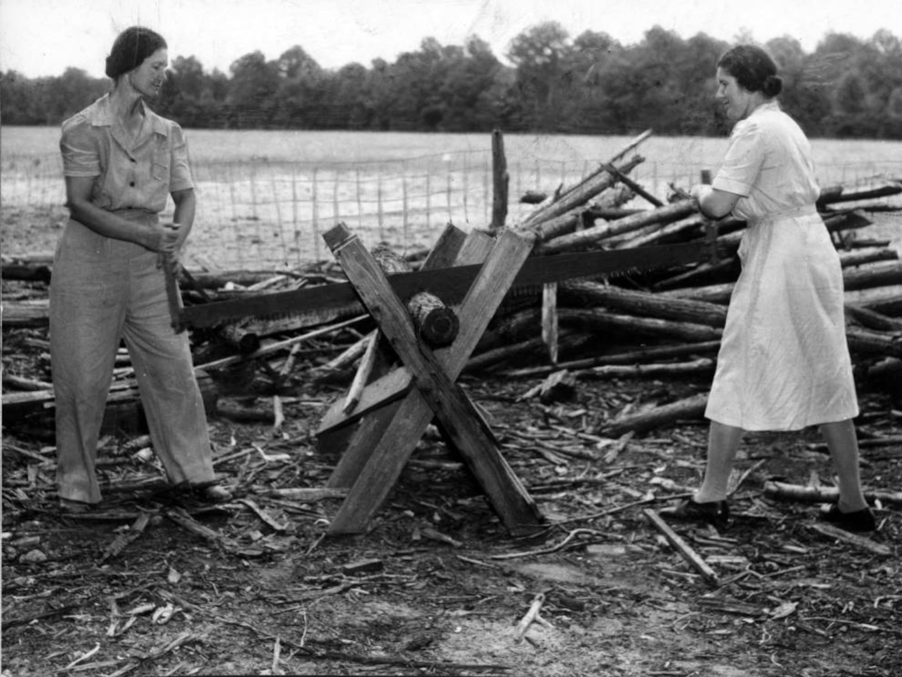 Catherine (left) and Rachel Meldrim cutting stove wood near Savannah on July 6, 1944.