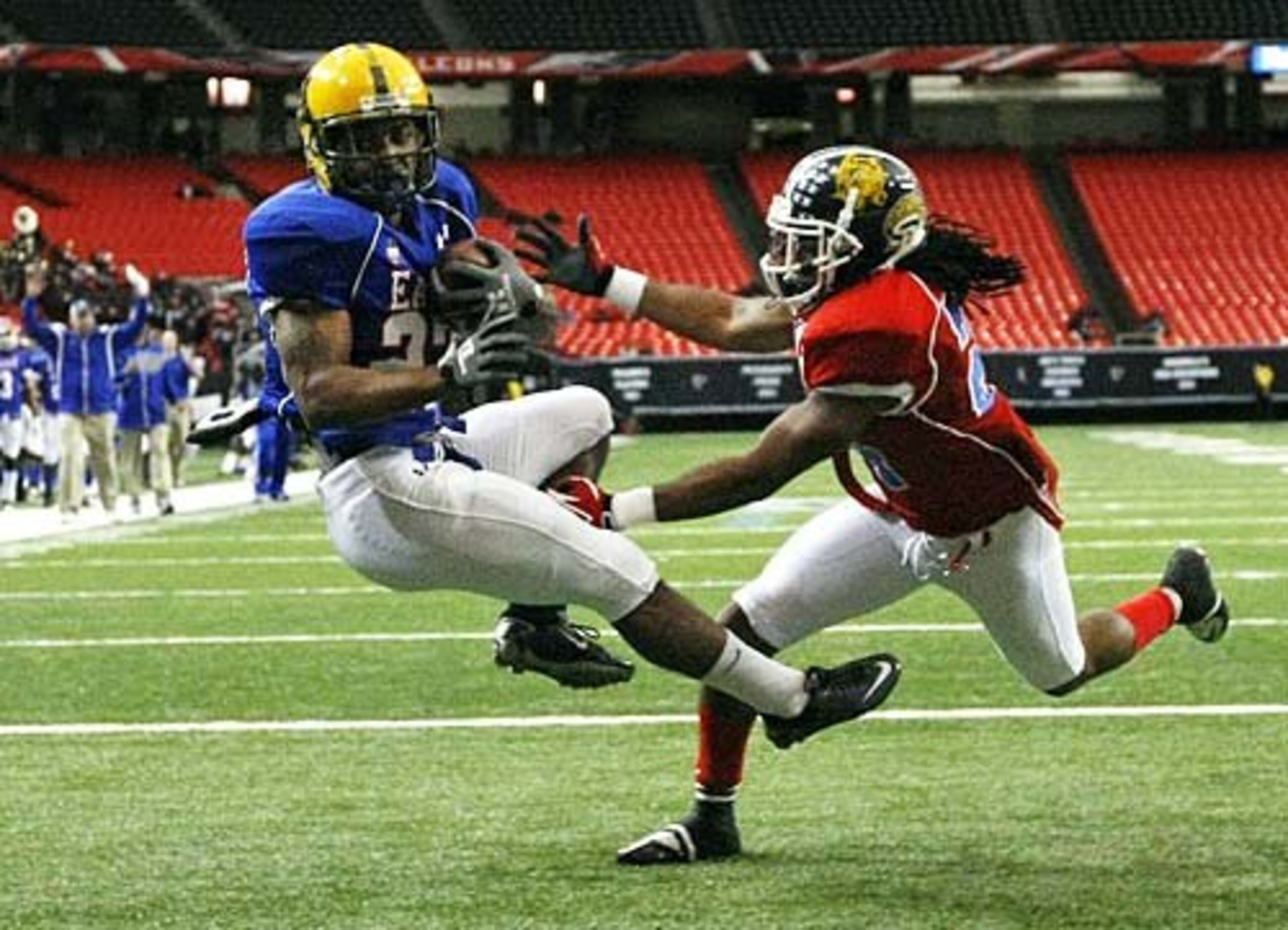 East wide receiver Victor Hairston, left, makes the touchdown catch in the endzone for a 10-0 lead holding on as he takes the hit from West defensive back Tim Dandridge.