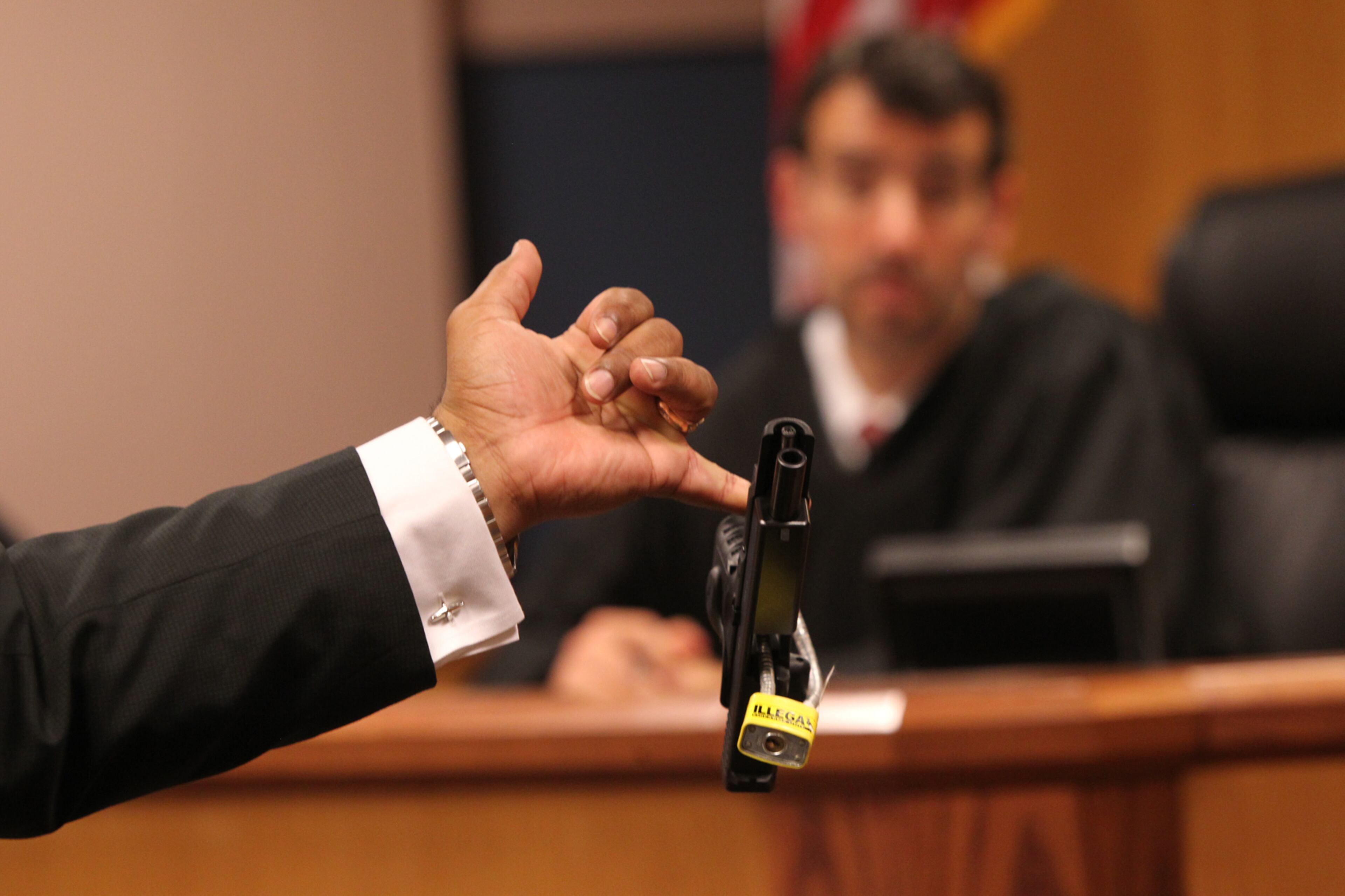 April 21, 2017, Atlanta, Georgia - Fulton assistant district attorney Clint Ruckers presents the handgun found at the home of Tex McIver to Judge Robert McBurney at a court appearance for prominent Atlanta attorney Tex McIver in Atlanta, Georgia, on April 21, 2017. McIver may have his bond revoked after authorities conducting a search found a gun stored in a drawer full of socks at his home. One of the conditions of McIver's bond was that he was not to have any guns, and the story only got stranger when it came forth that his attorney, Stephen Maples, told Tammy Johnson to remove it from the home after it was discovered by authorities. (HENRY TAYLOR / HENRY.TAYLOR@AJC.COM)