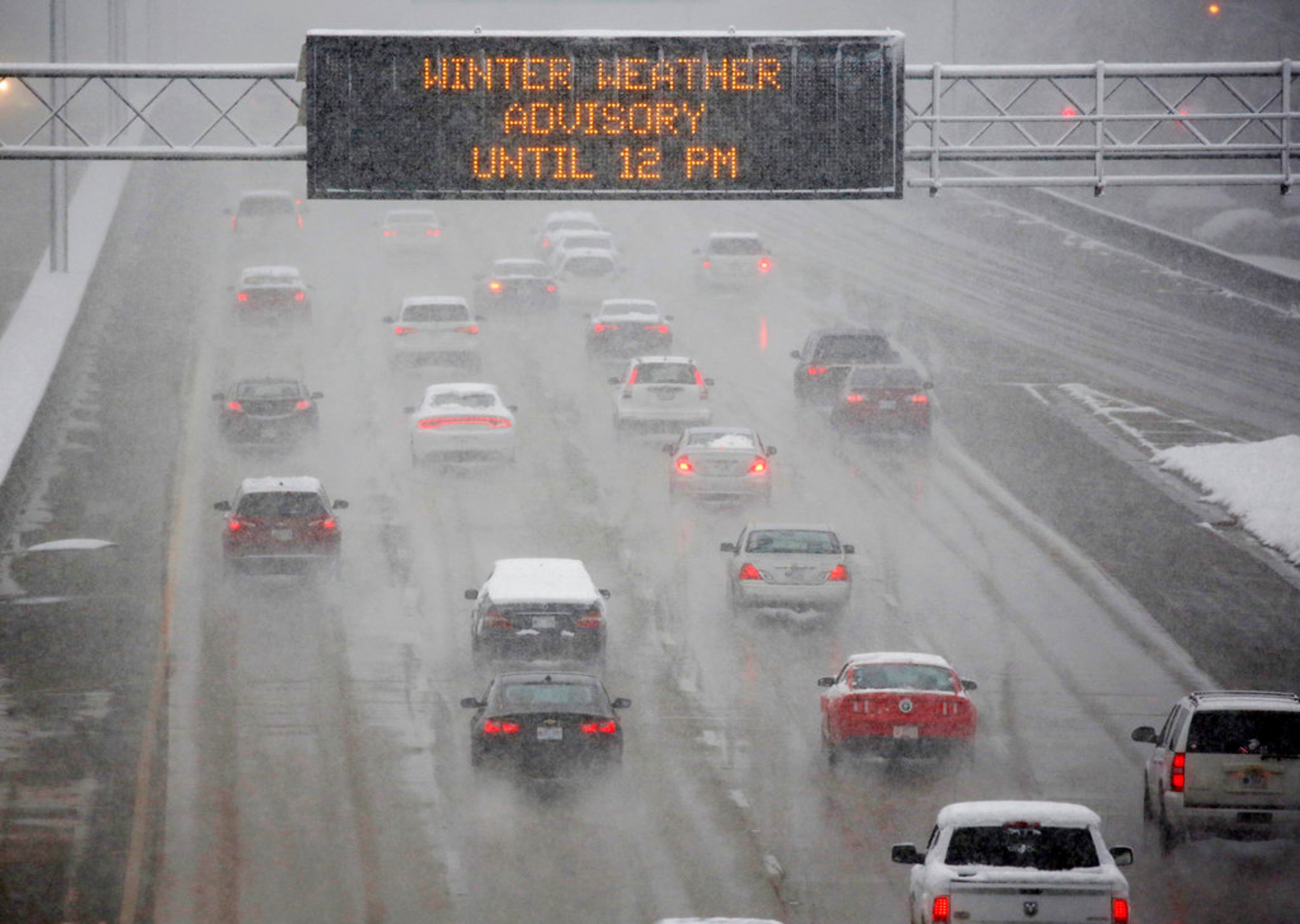 A heavy morning snow falls in Jackson, Miss., Friday, Dec. 8, 2017, as an electronic sign posts a winter weather advisory for drivers along I-55. The forecast called for a wintry mix of precipitation across several Deep South states. (AP Photo/Rogelio V. Solis)