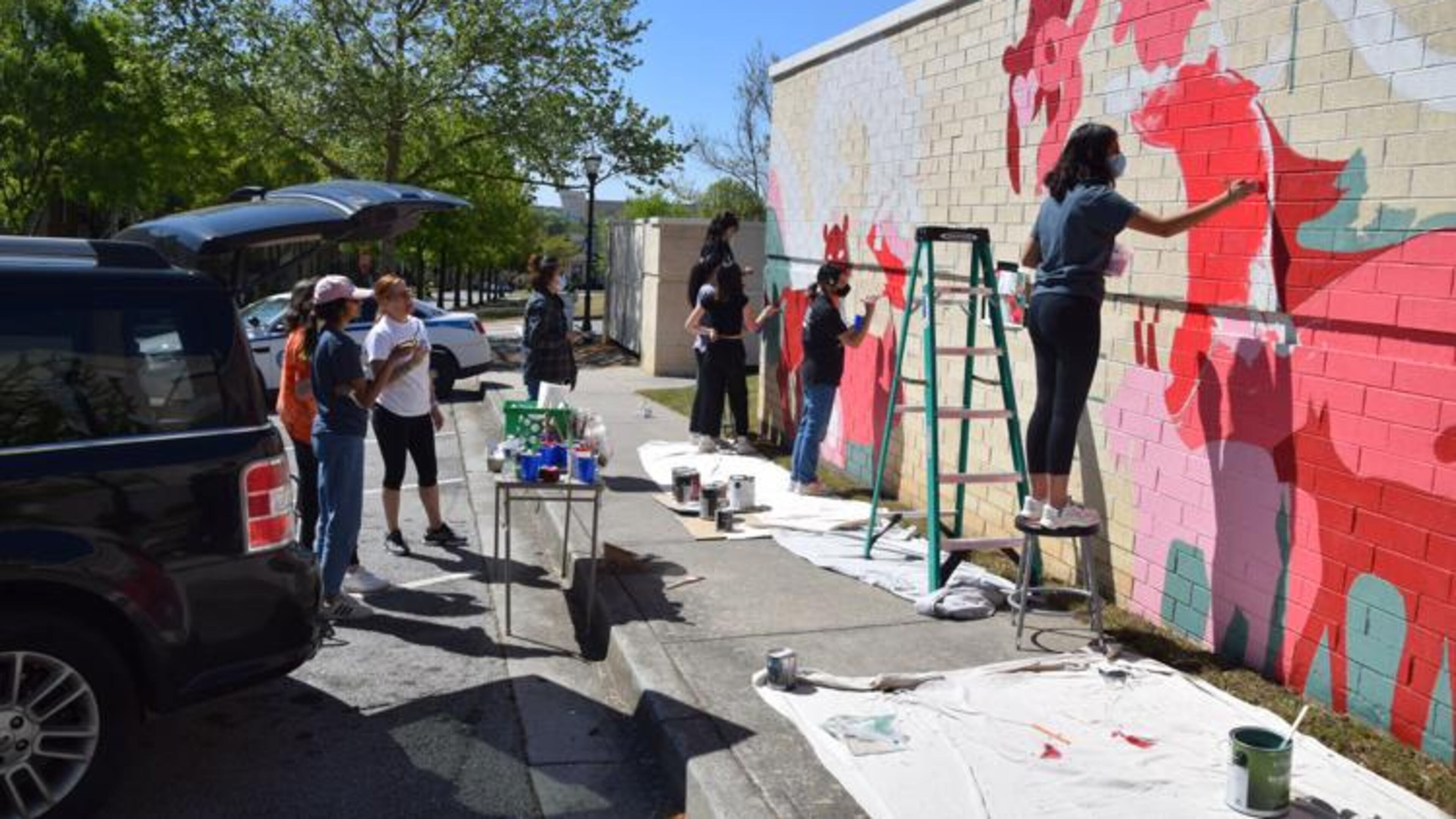 North Gwinnett High School arts honor students work on a Chinese zodiac mural in downtown Suwanee. (Courtesy of Curt Yeomans)