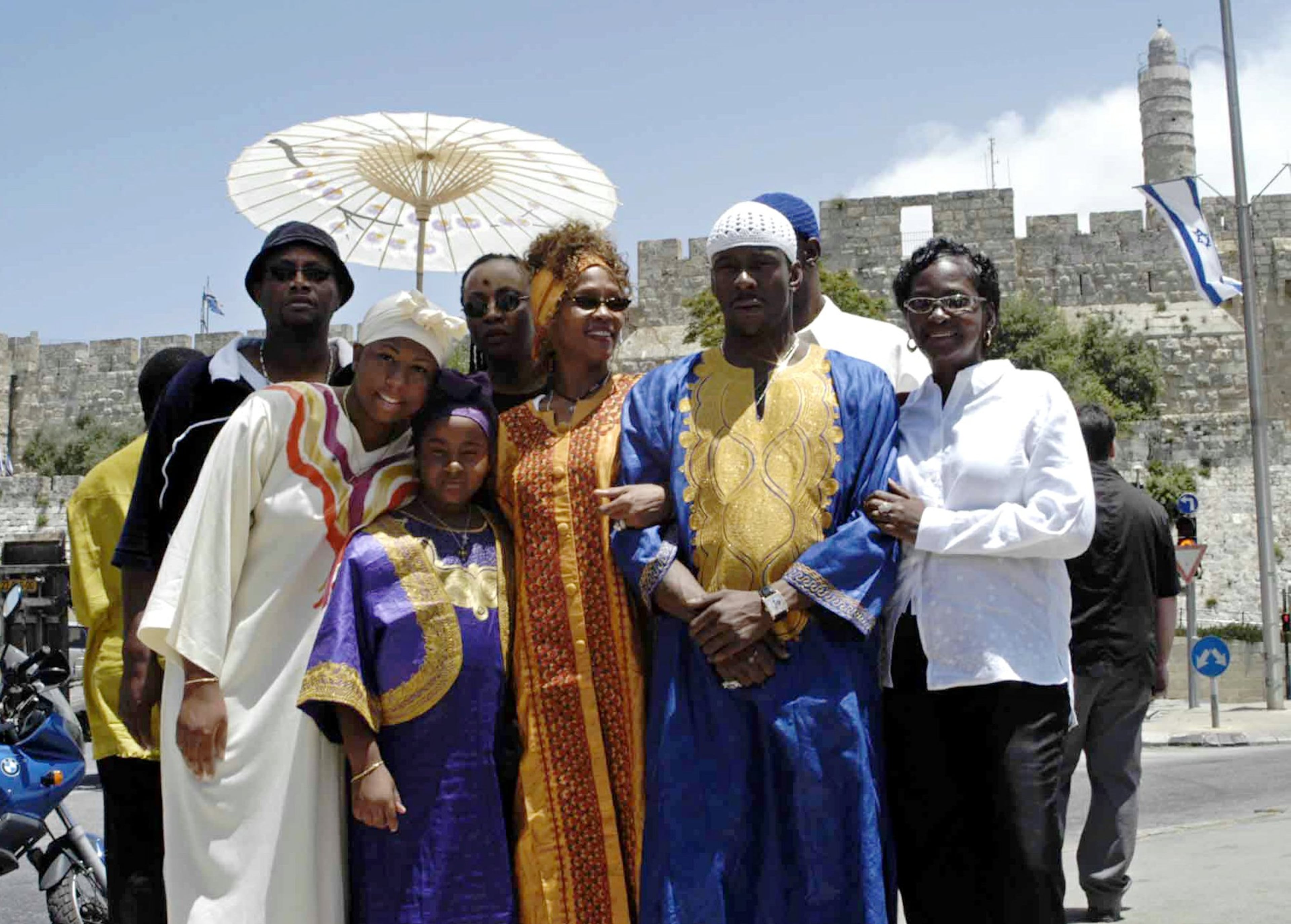 Entertainer Whitney Houston, center, her husband Bobby Brown, second right, and other members of her entourage pose for a photo near Jerusalem's Old City walls Wednesday May 28, 2003. Houston is in Israel to visit the Black Hebrews, an African-American community that moved to Israel in 1969 and settled in the southern town of Dimona. (AP Photo/Zoom 77)