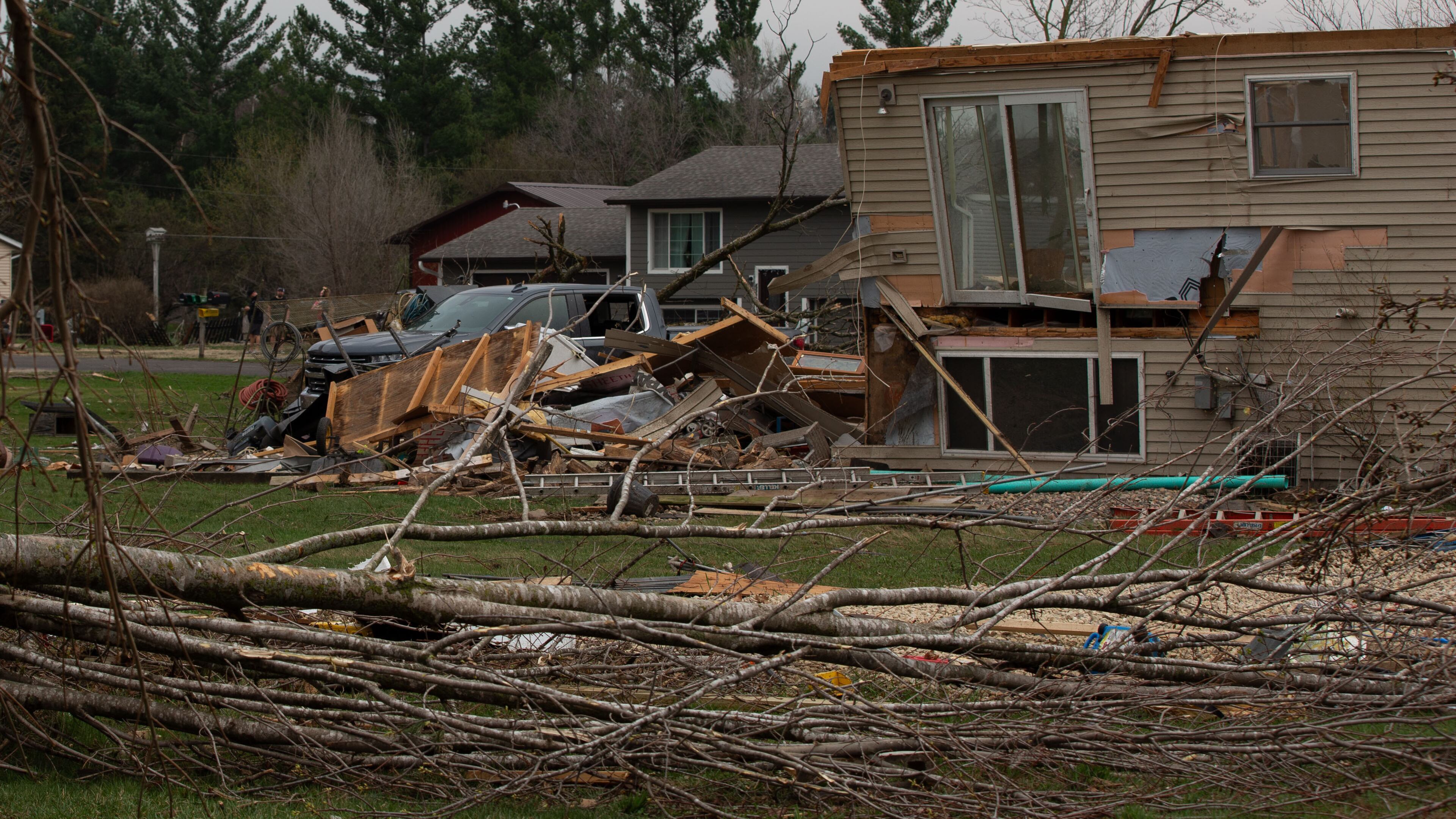 Debris and fallen tree limbs cover the ground after a severe storm that tore through the Upper Midwest on Friday, April 17, 2026, in Rochester, Minn. (Hollie Bennett Piotrowicz via AP)