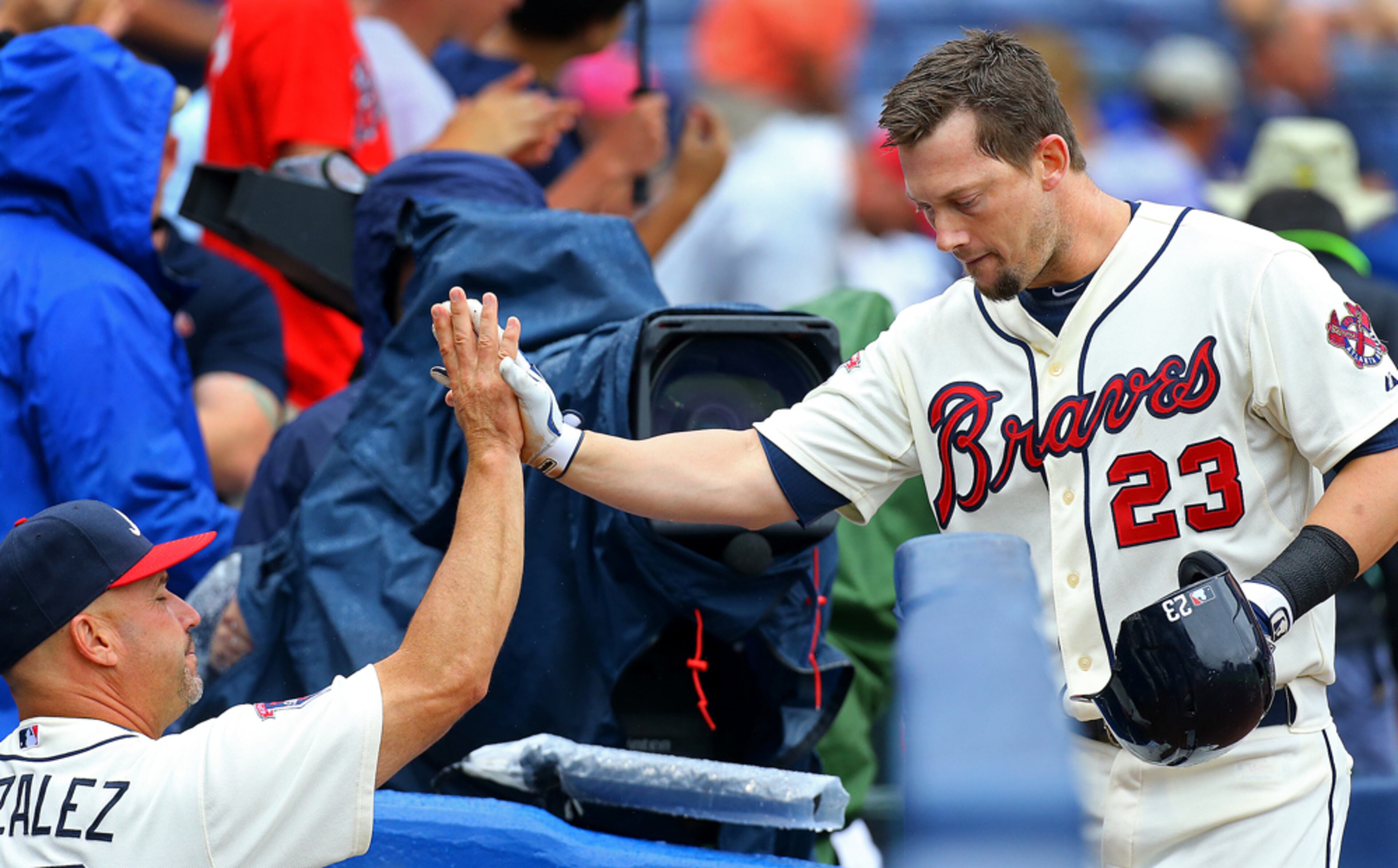 HIGH FIVES--072014 ATLANTA: Braves manager Fredi Gonzalez gives Chris Johnson a high five at the dug out after he hits a two run homer to take a 2-1 lead over the Phillies during the second inning of an MLB game on Sunday, July 20, 2014, in Atlanta. CURTIS COMPTON / CCOMPTON@AJC.COM