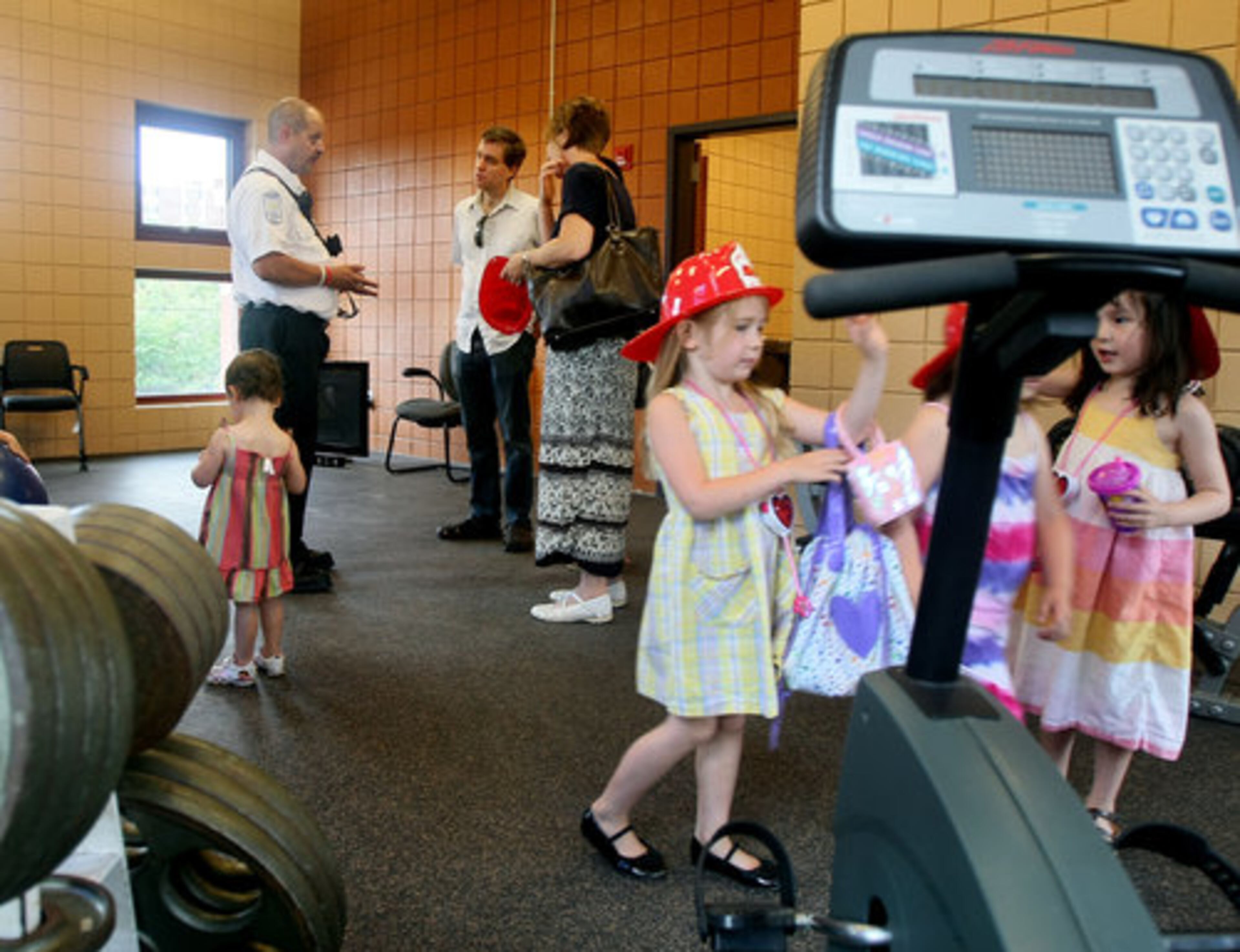 Chief James Peal (left, in white shirt) leads a tour of the new Fire Station 13 exercise room. Completion of the new station has allowed City of Atlanta firefighters to move across the street into the new location.
