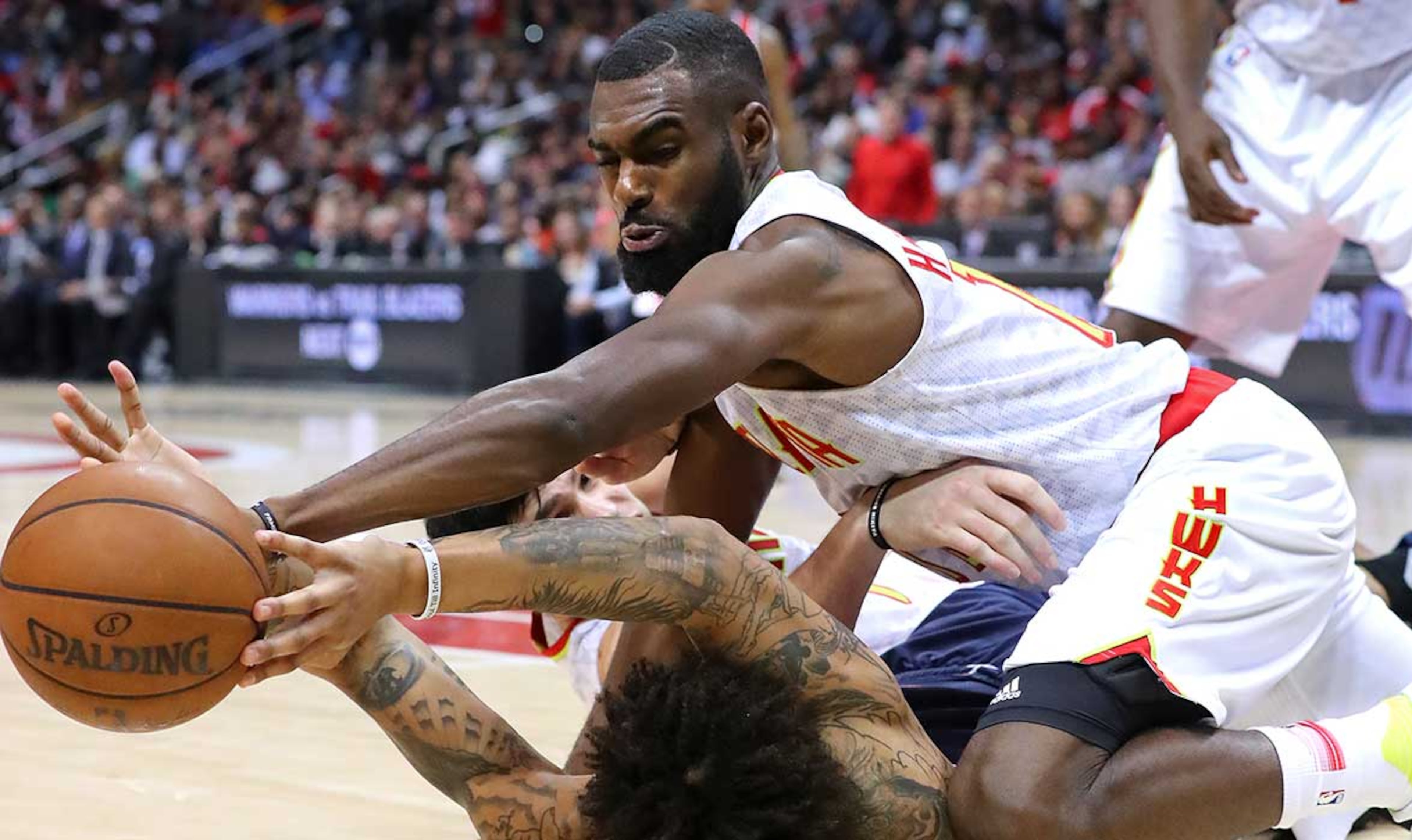Tim Hardaway Jr. battles Washington's Kelly Oubre for a loose ball during Monday's NBA playoff game at Philips Arena. The Hawks defeated the Wizards to even the best-of-seven first-round series at 2-2.