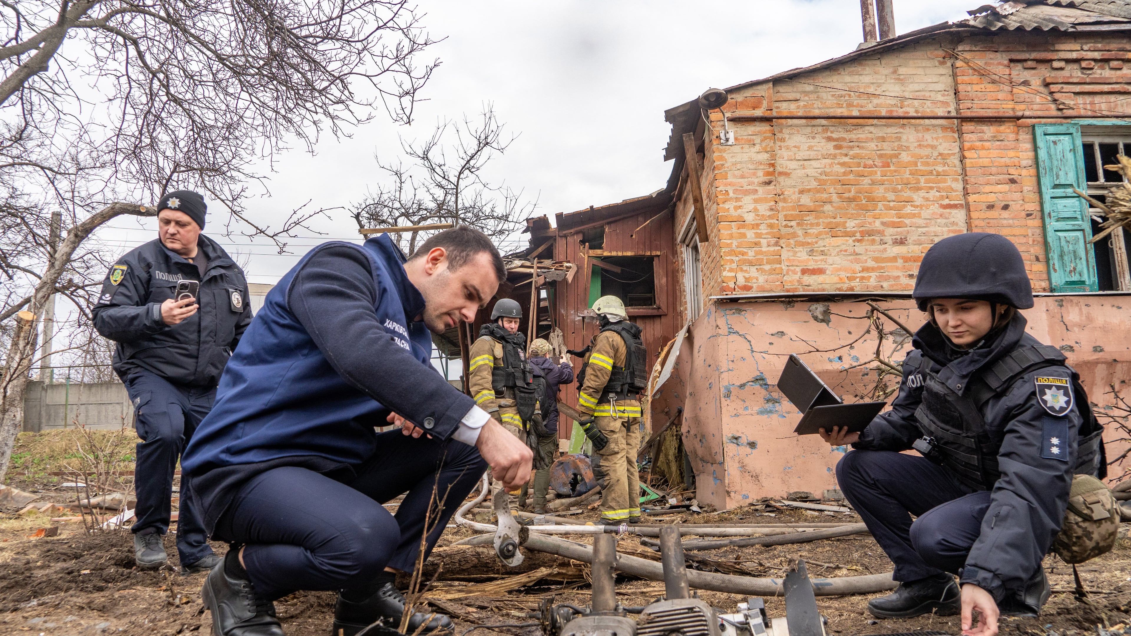 Police officers examine the fragments of a Russian drone that hit a private house during air attack in Kharkiv, Ukraine, Wednesday, March 25, 2026. (AP Photo/Andrii Marienko)