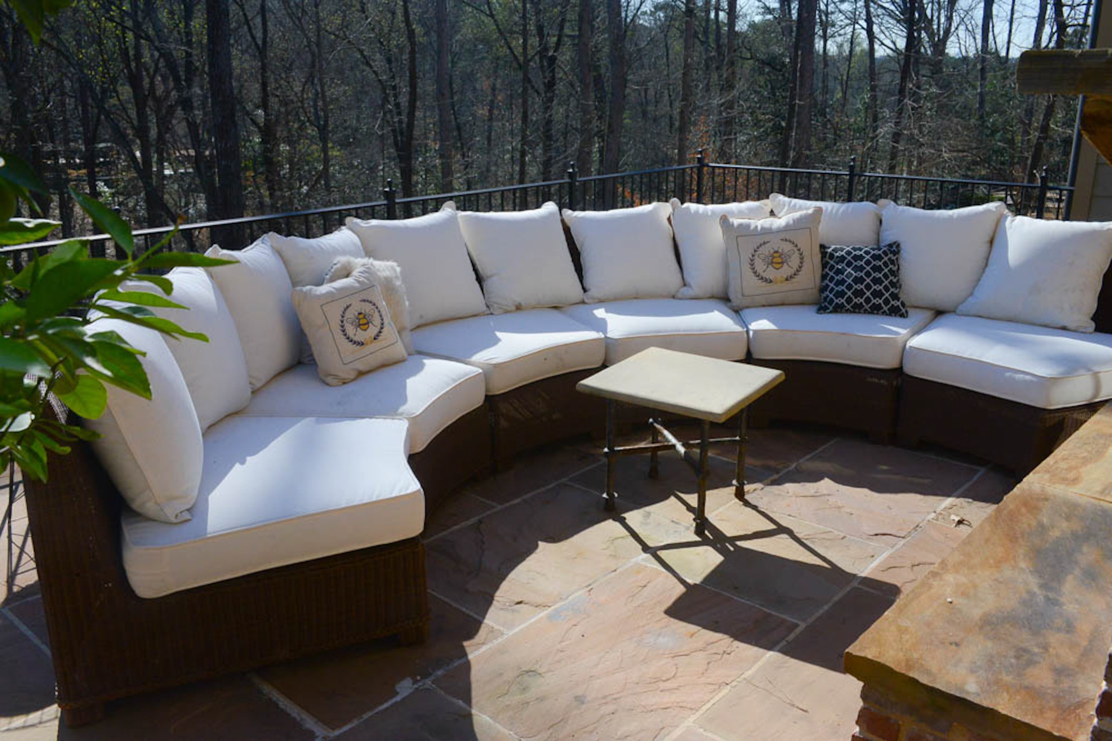 A semi-circular outdoor sectional provides a comfortable spot for Alan and Jeanmarie Quarterman to entertain or relax as they look over their wooded backyard in Buckhead.