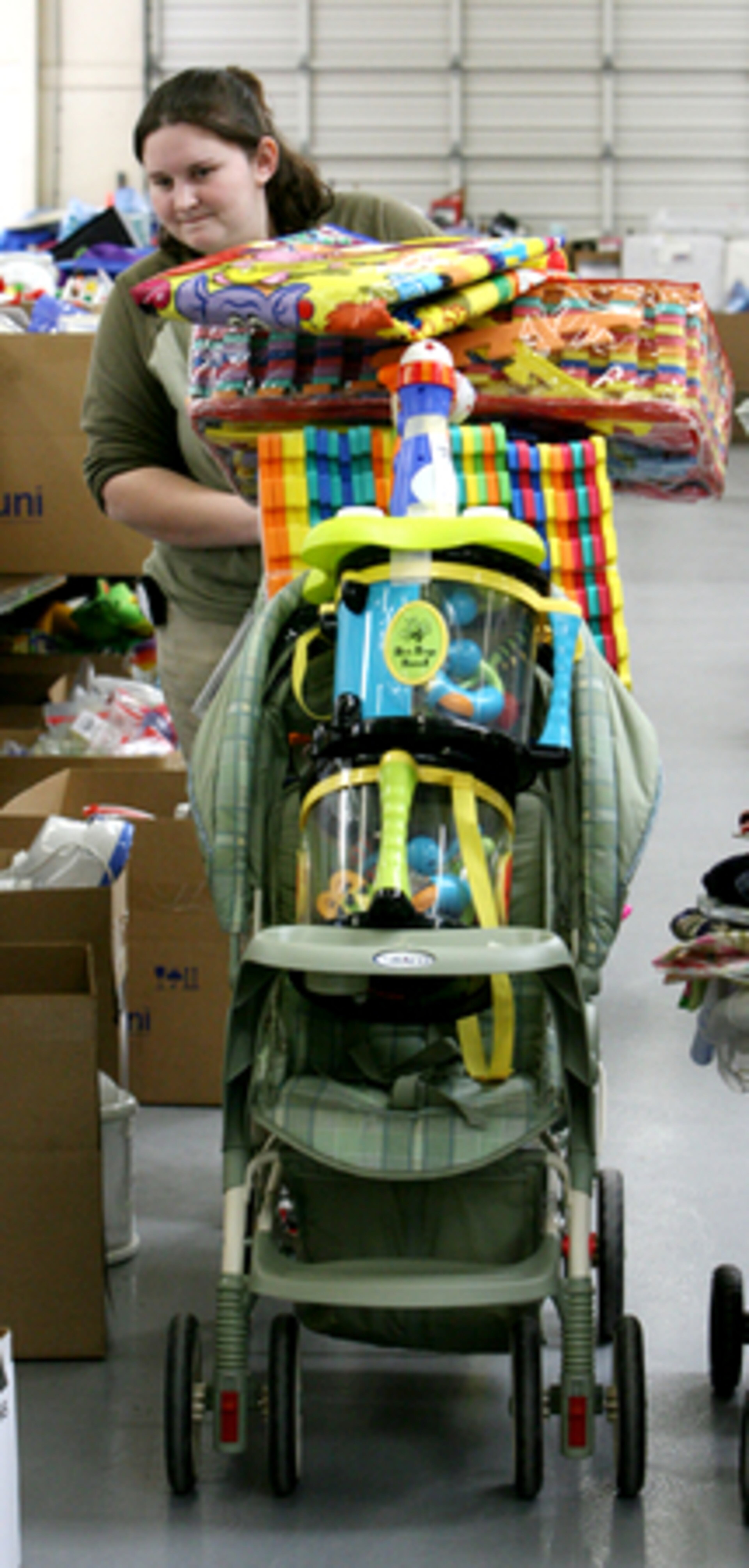 Volunteer Kristen Underwood of Doraville wheels a stroller she is buying that she has filled with all sorts of baby items for her daughter Addy, age 10 months, and to share with her cousin.