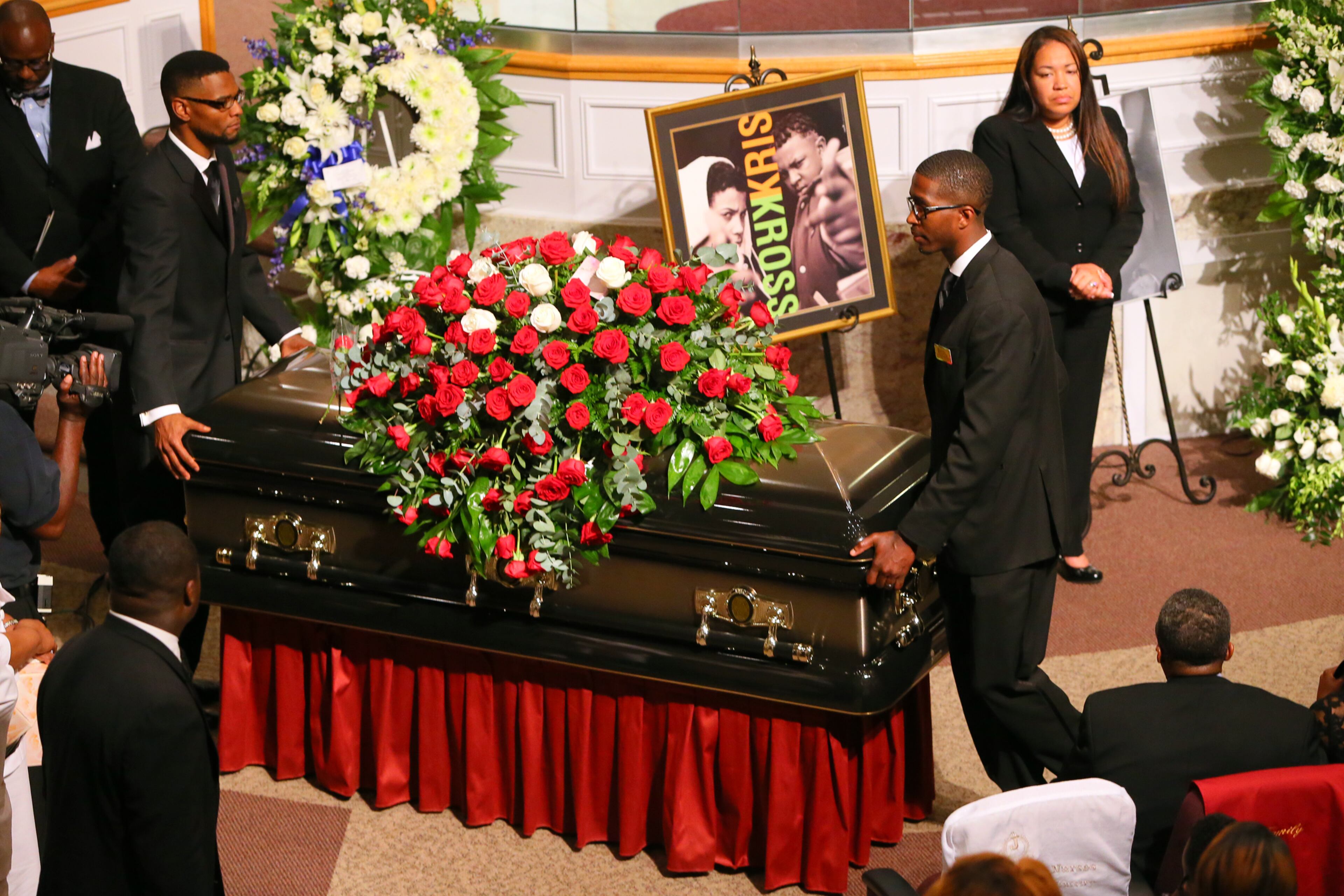 The flower-covered coffin of Chris Kelly leaves in a recessional at the conclusion of his funeral.