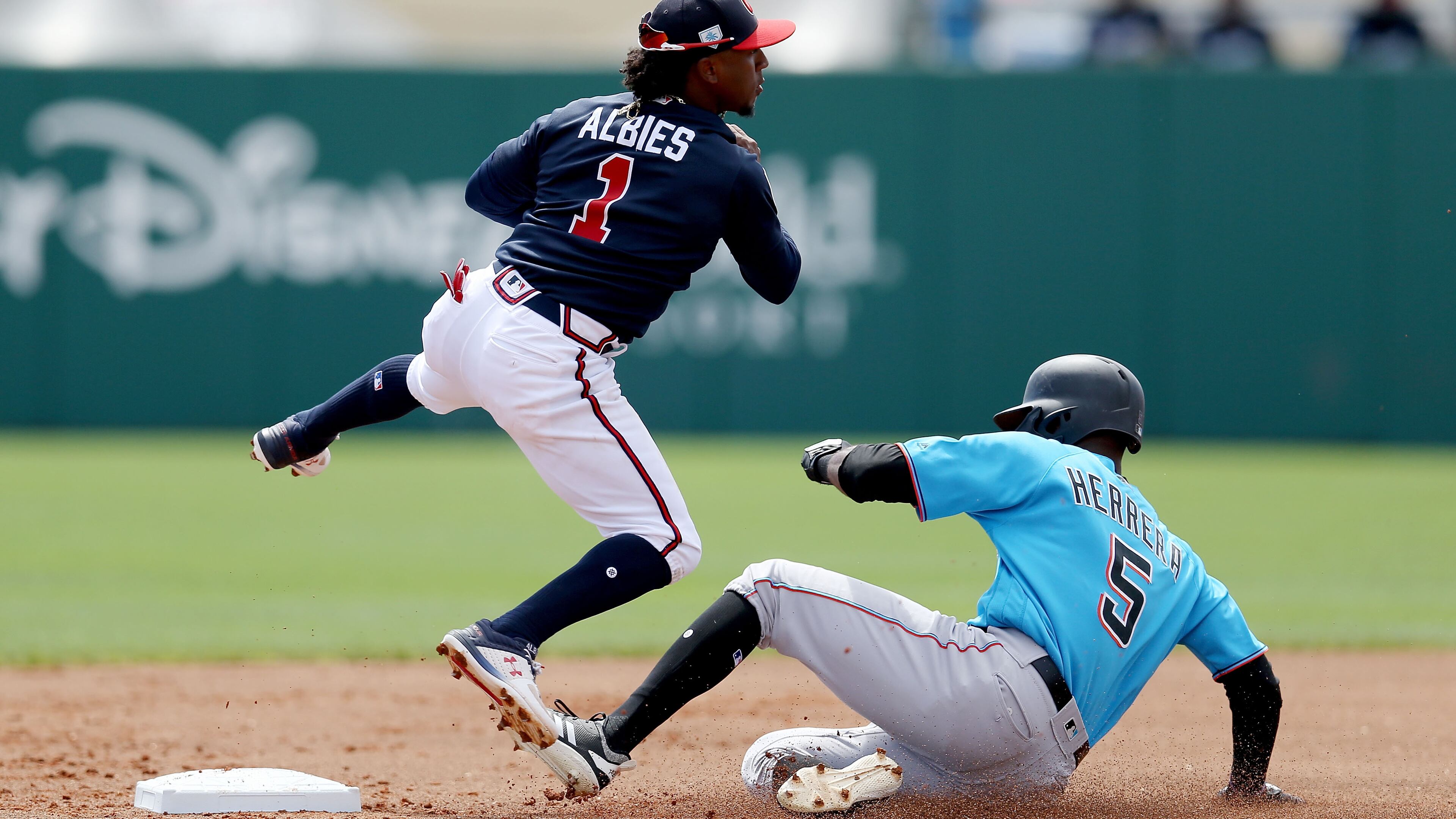 Braves' Ozzie Albies turns a double play past Marlins' Rosell Herrera in the first inning Sunday, March 3, 2019, at Champion Stadium in Lake Buena Vista, Fla.