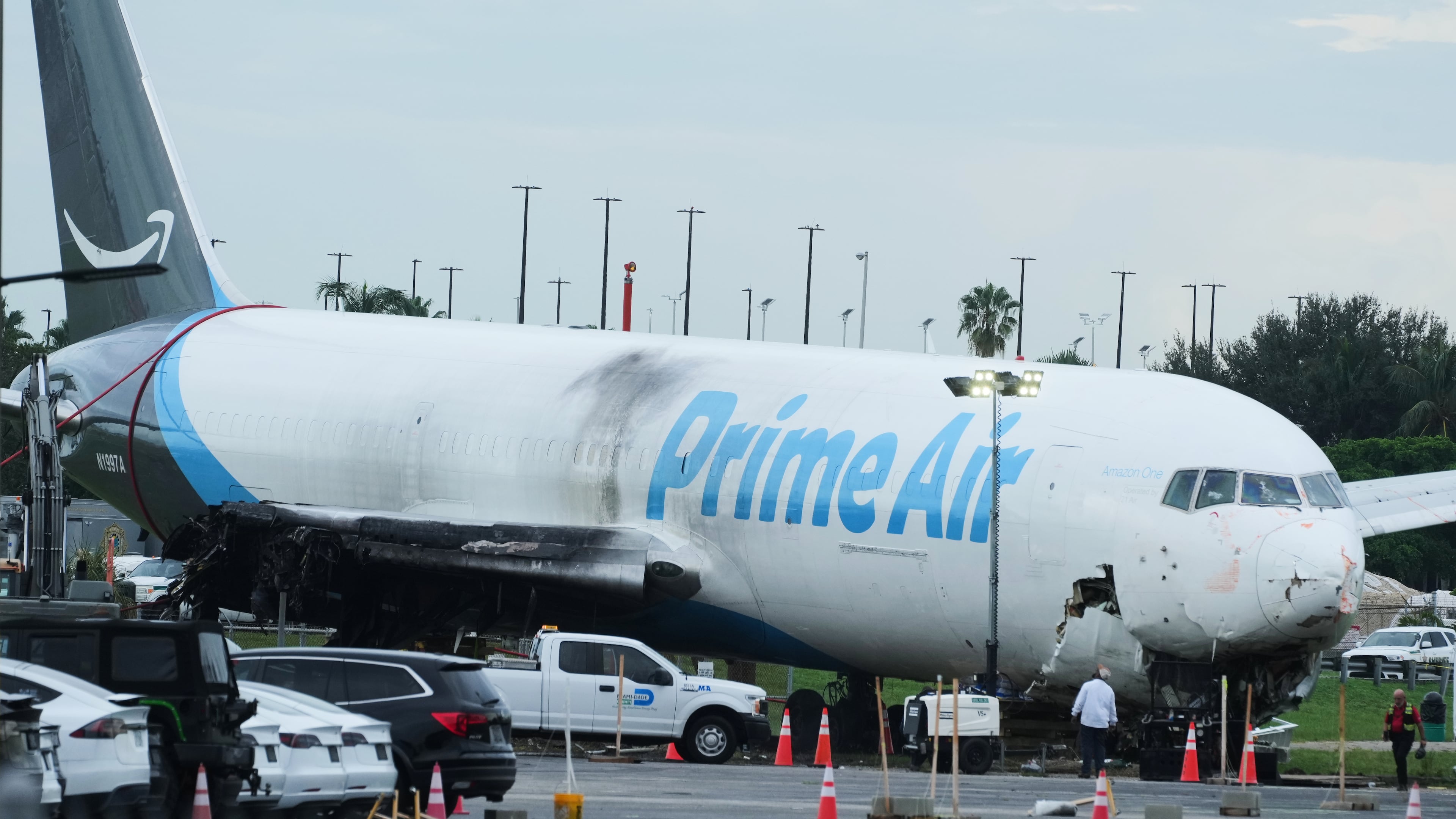Workers inspect an Amazon cargo plane that overshot a runway four days ago at Miami International Airport, Thursday, Sept. 10, 2026, in Miami. (AP Photo/Marta Lavandier)