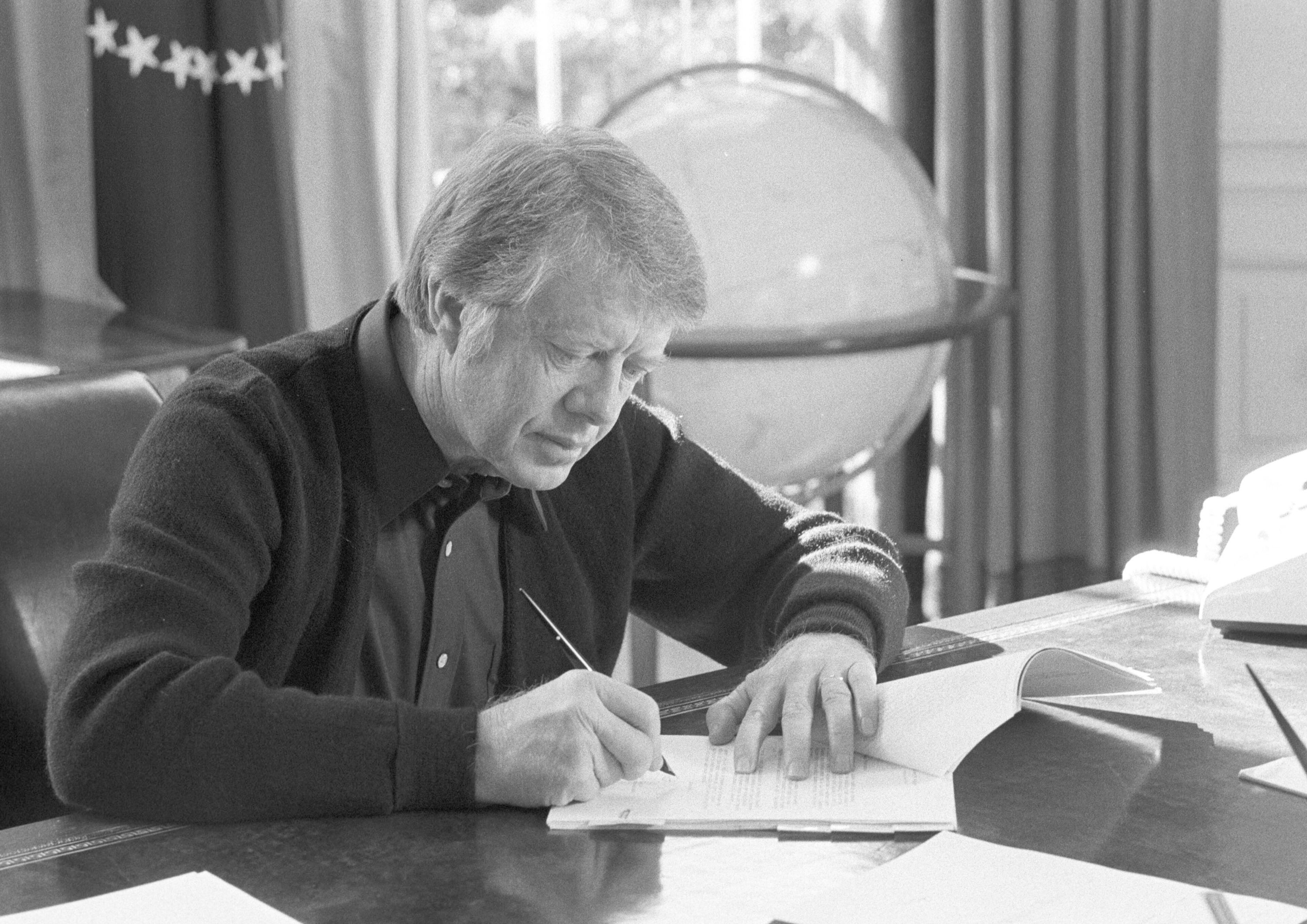 President Carter works at his desk in the Oval Office on February 8, 1977. (Jimmy Carter Library)