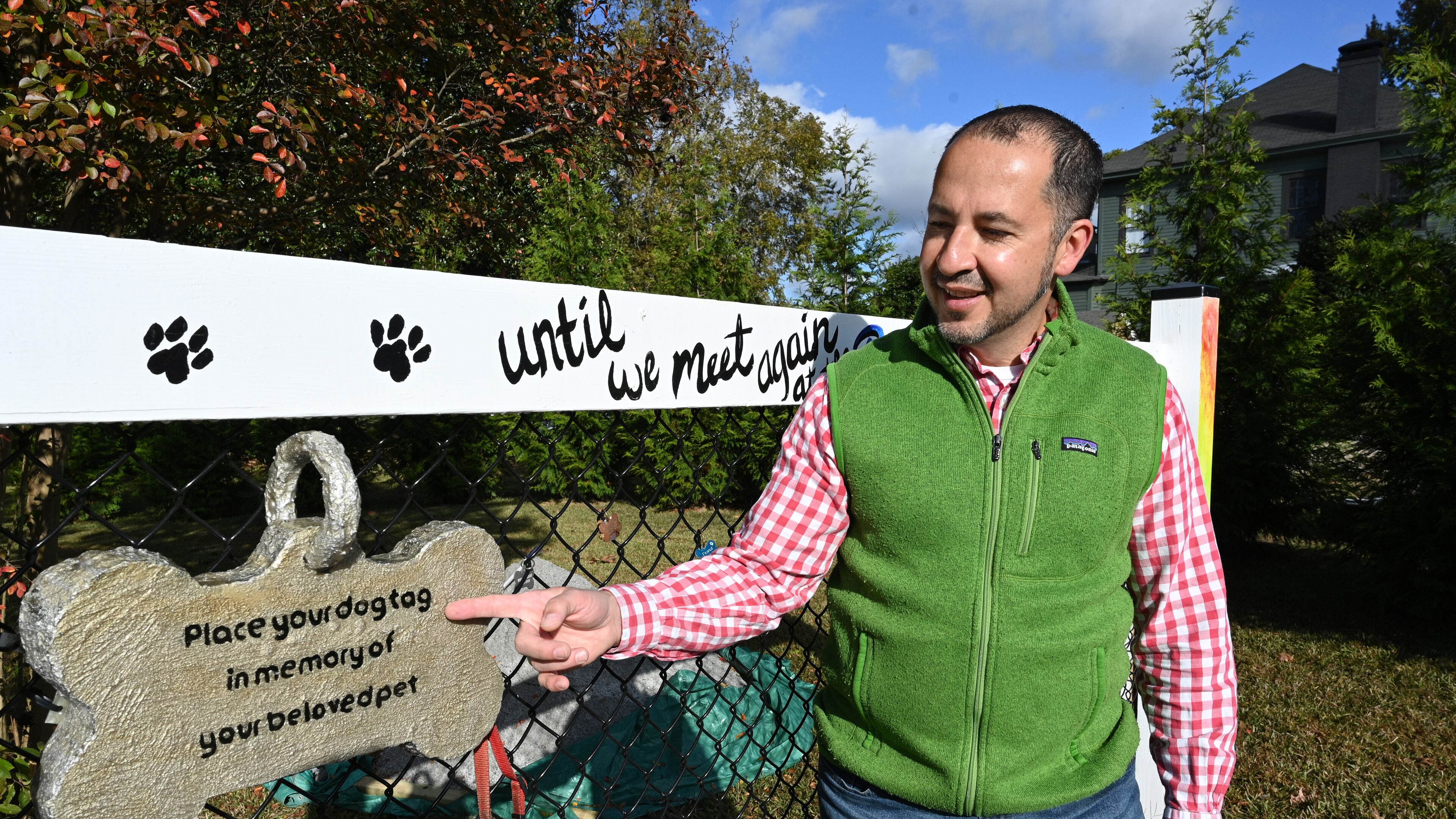 Dr. Humberto Fallas with dogtags, other pet owners have hung, at a memorial of his German shepherd, Ace, near his office Fallas Family Vision in McDonough.(Hyosub Shin / Hyosub.Shin@ajc.com)