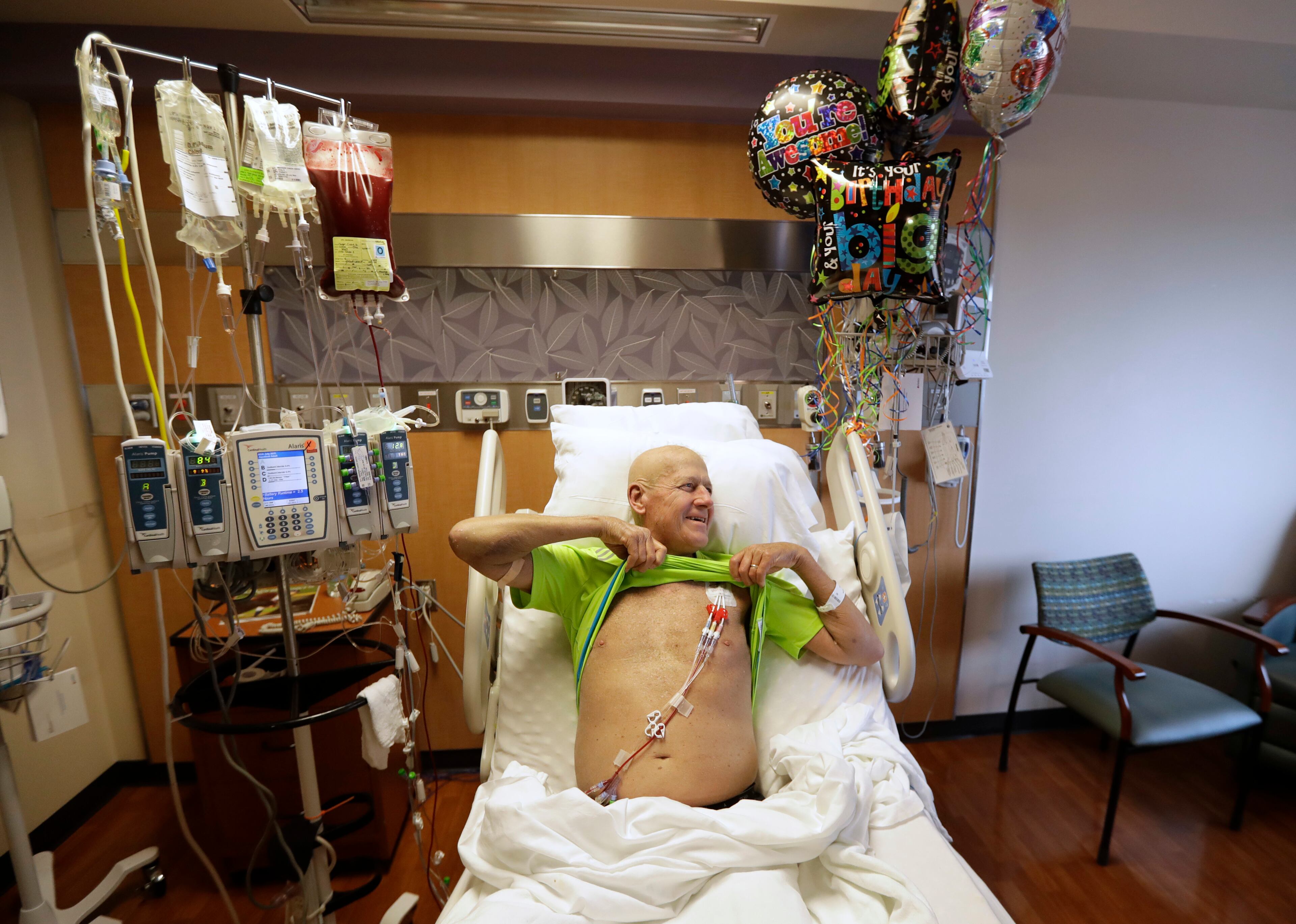 Sportscaster Craig Sager holds up his shirt as his wife Stacy takes a picture after starting his transplant procedure Wednesday, Aug. 31, 2016, at MD Anderson Cancer Center in Houston. Sager underwent his third bone marrow transplant as he continues to battle Acute myeloid leukemia. (AP Photo/David J. Phillip)