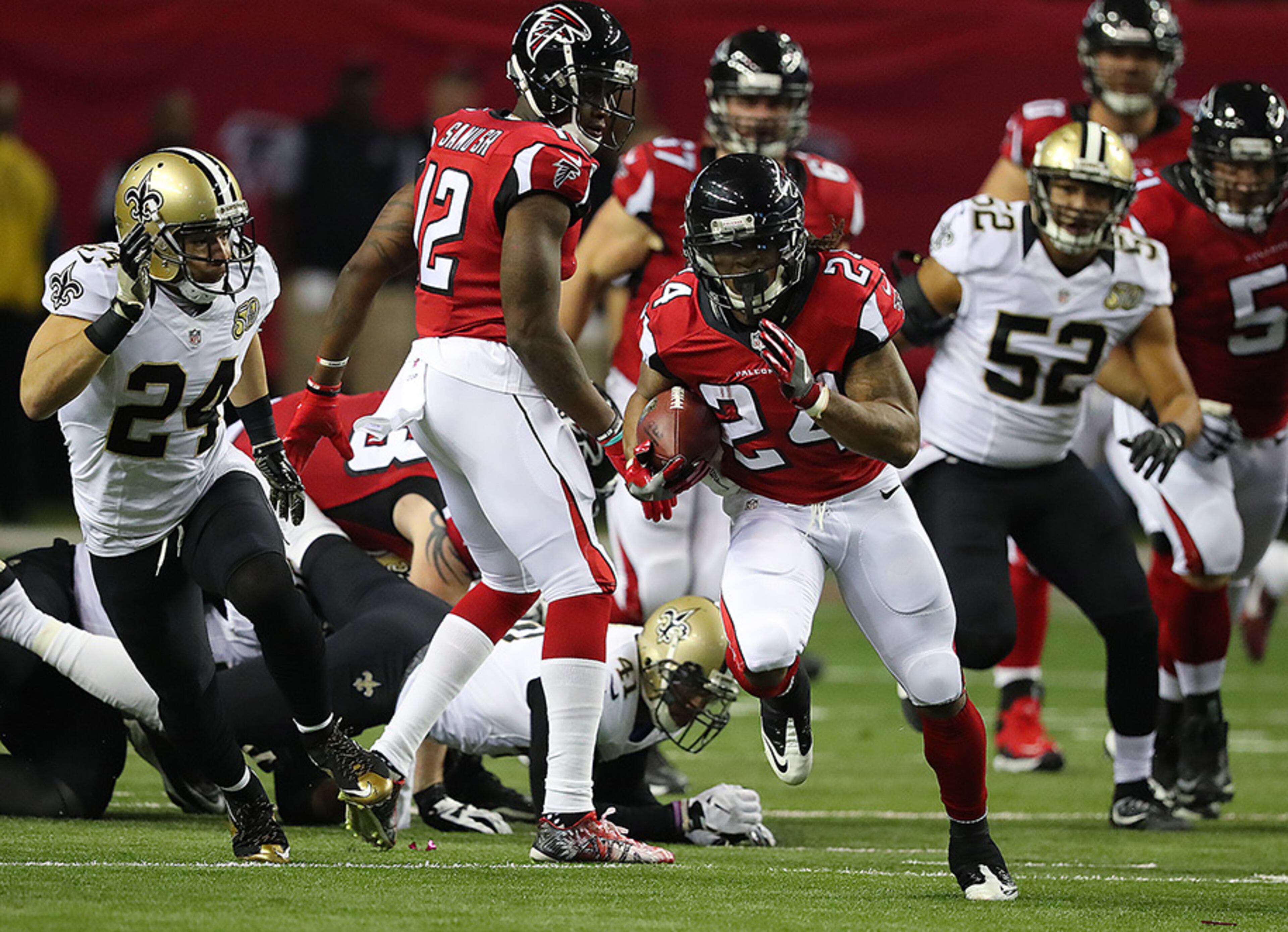 Falcons running back Devonta Freeman breaks away from Saints defenders for a 75-yard touchdown run to take a 14-3 lead during the first quarter Sunday, Jan. 1, 2017, at the Georgia Dome in Atlanta.