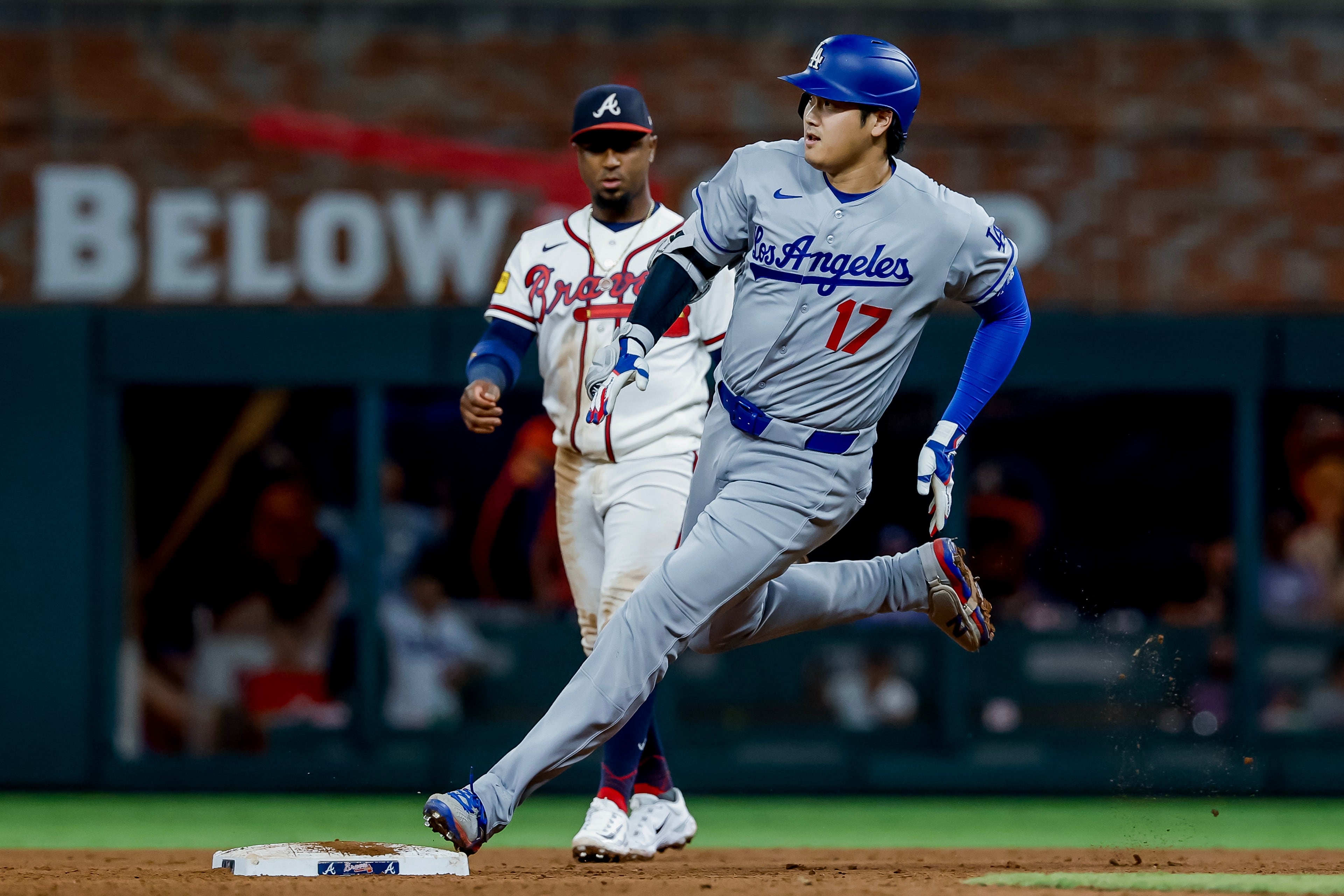 Los Angeles Dodgers designated hitter Shohei Ohtani (17) rounds second base after hitting a triple as Atlanta Braves second baseman Ozzie Albies (1) looks on during the ninth inning of a baseball game, Tuesday, Aug. 25, 2026, in Atlanta. (AP Photo/Erik S. Lesser)