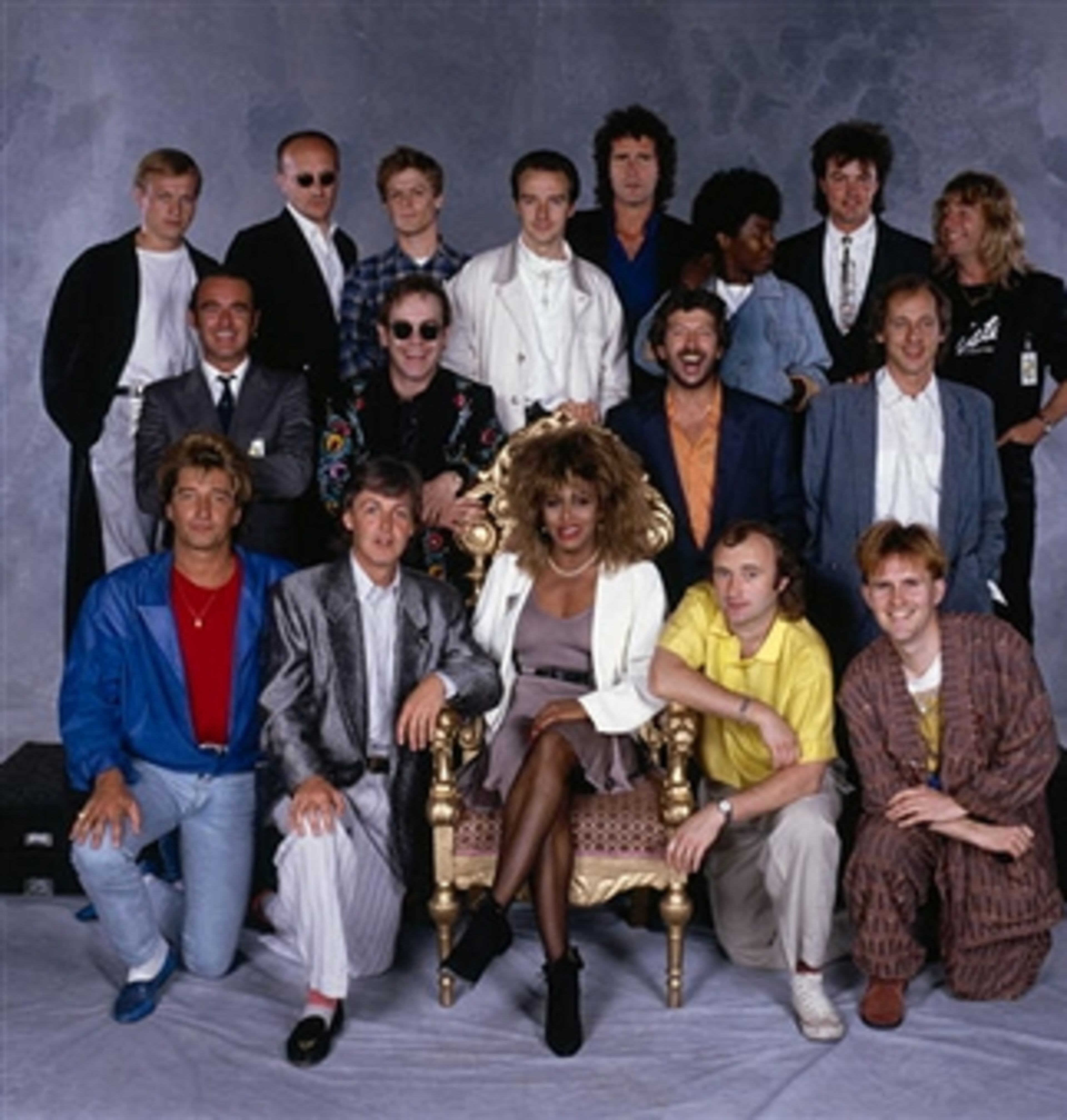 Internationally famous musicians gather for the Prince's Trust 10th Anniversary Rock Gala at Wembley, 23rd June 1986. From left to right (top row) Mark King of Level 42, Ray Cooper, Bryan Adams, Midge Ure, John Illsley, Joan Armatrading, Paul Young, Rick Parfitt; (middle row) Francis Rossi, Elton John, Eric Clapton, Mark Knopfler; (front row) Rod Stewart, Paul McCartney, Tina Turner, Phil Collins, Howard Jones. (Photo by Terry O'Neill/Hulton Archive/Getty Images)