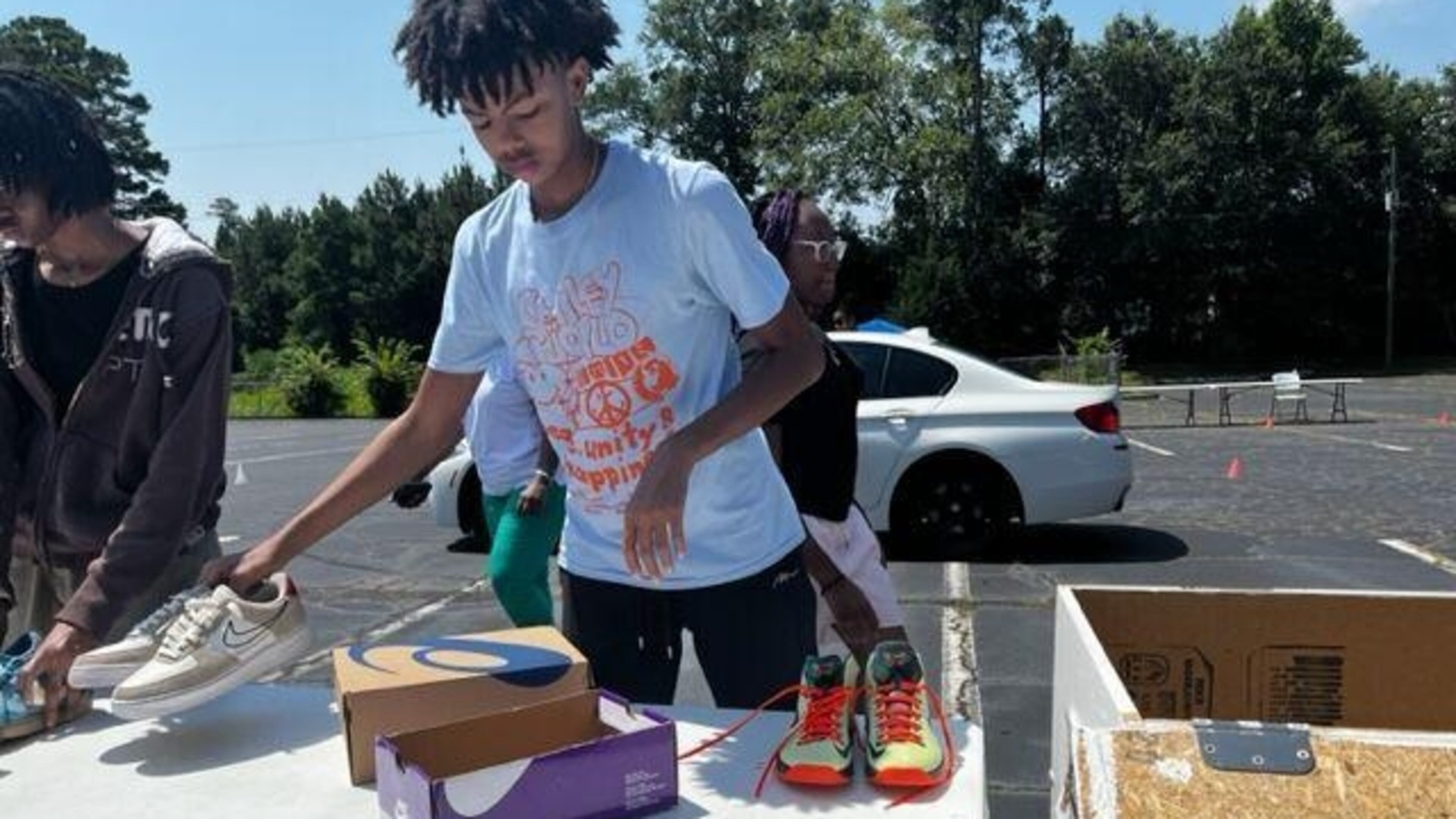 Caleb Sanders separates shoes by sizes during the launch of his initiative, Kicks for Kids. (Photo provided by Clayton News-Daily)