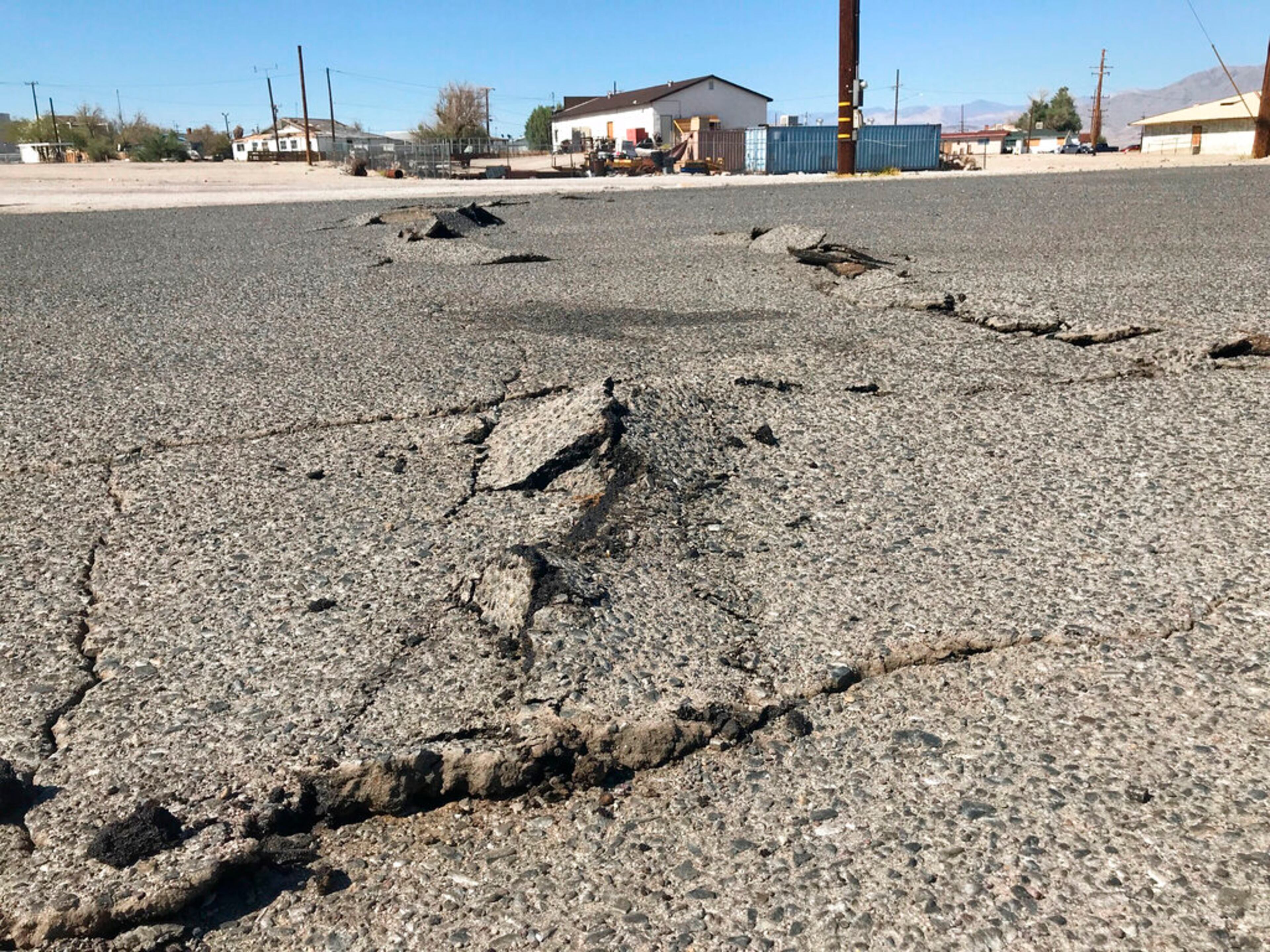 A road is damaged from an earthquake Thursday, July 4, 2019, in Trona, Calif. A strong earthquake rattled a large swath of Southern California and parts of Nevada on Thursday, rattling nerves on the July 4th holiday and causing some damage in a town near the epicenter, followed by a swarm of aftershocks.