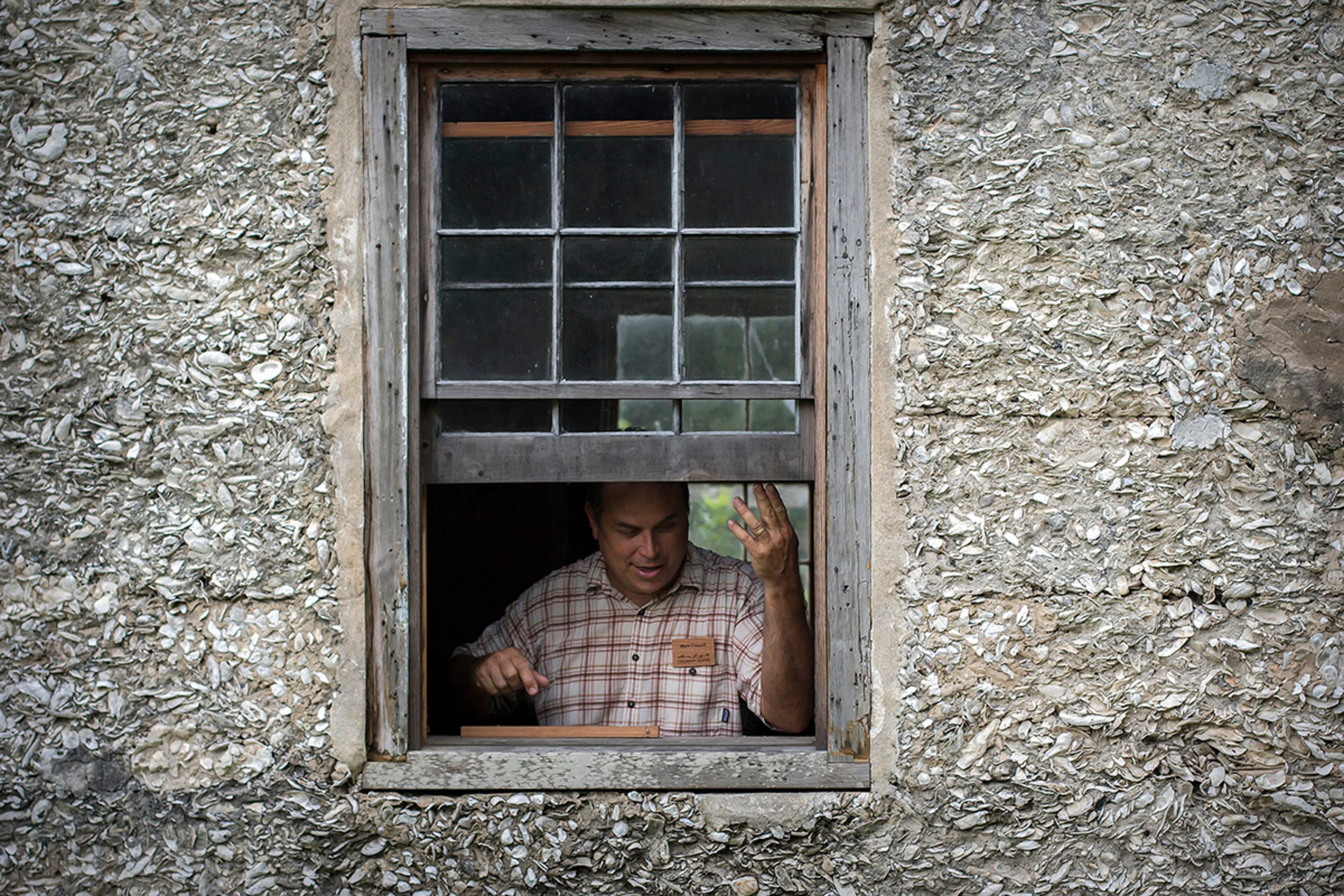 Mark Frissell, an Ossabaw Island Foundation historic preservationist, opens a reproduction window in cabin #2. (AJC Photo/Stephen B. Morton)