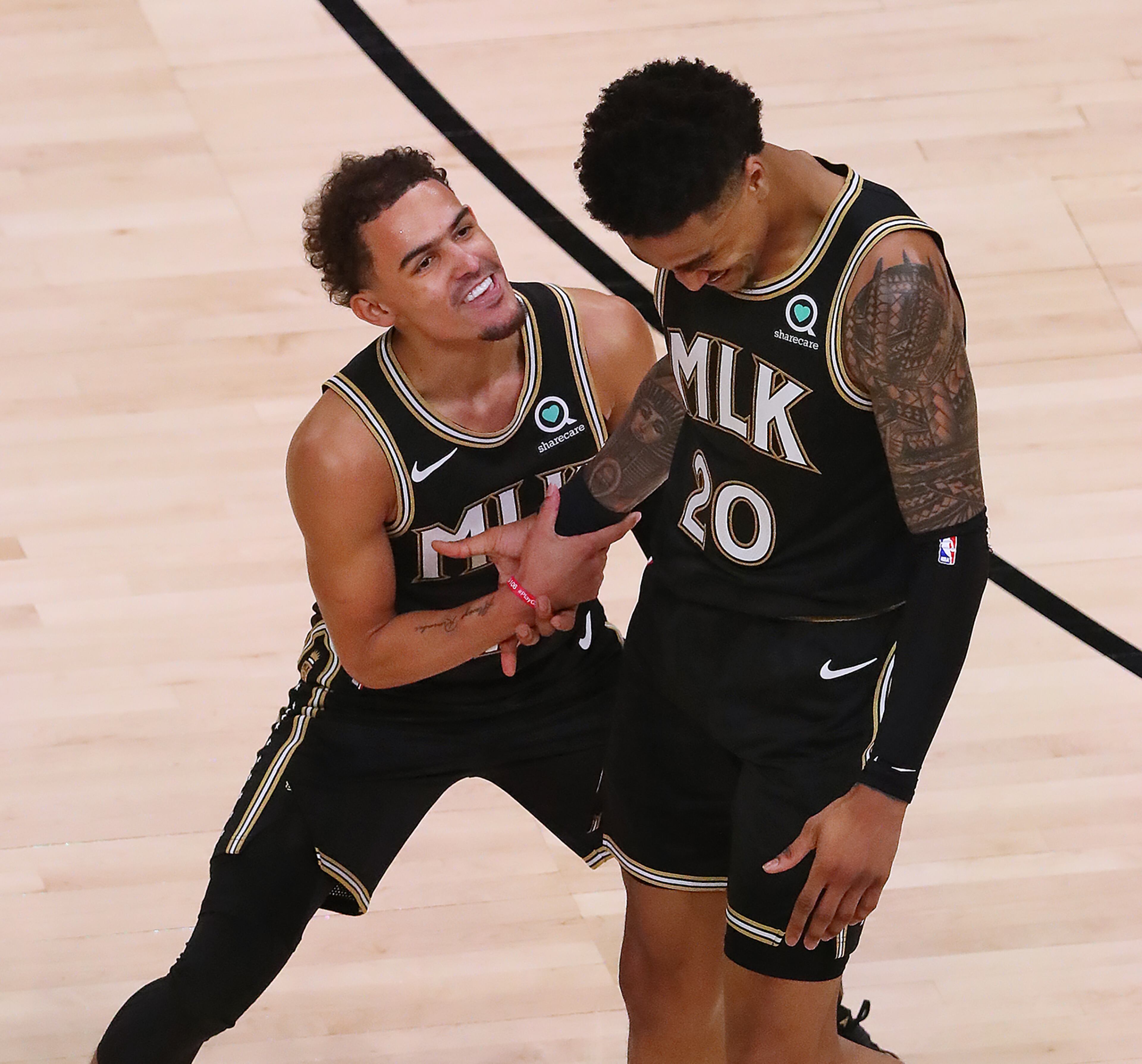 Hawks guard Trae Young celebrates with forward John Collins after he hit a three pointer, adding to Atlanta's second-half lead during Game 4 of their first-round NBA playoff matchup against the New York Knicks Sunday, May 30, 2021, at State Farm Arena in Atlanta. (Curtis Compton / Curtis.Compton@ajc.com)