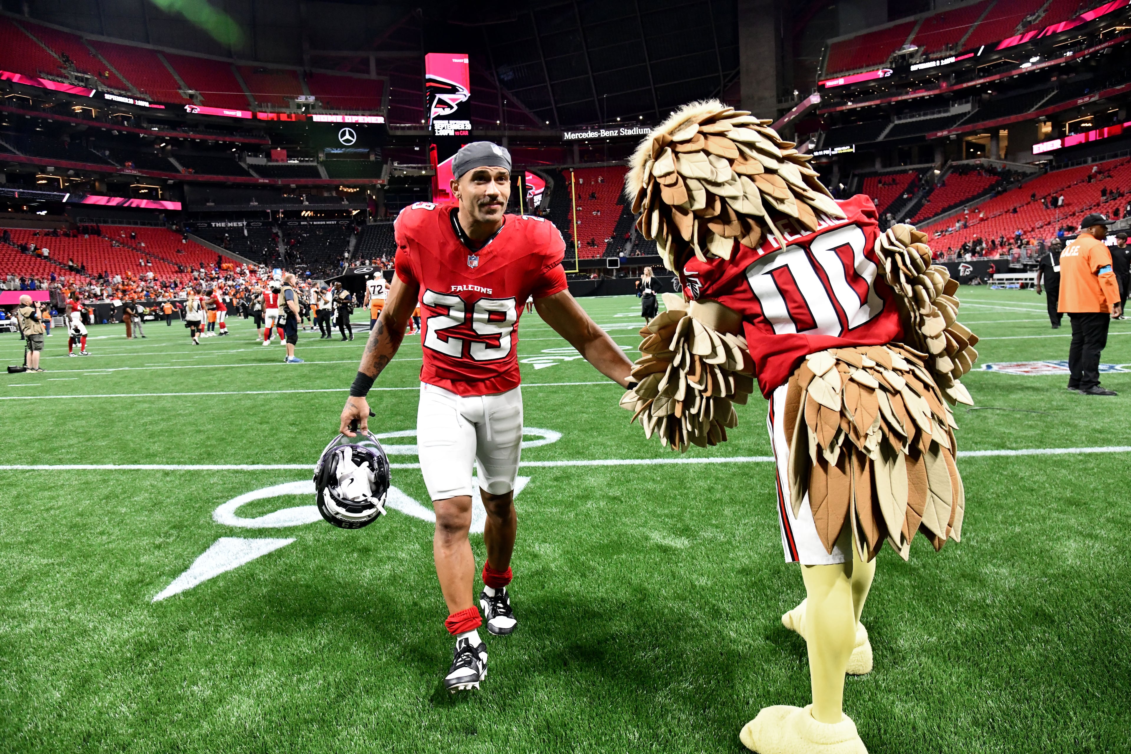 Falcons safety Sydney Brown gets a high-five from Freddie Falcon after their preseason game against the Denver Broncos at Mercedes-Benz Stadium on Friday, Aug. 14, 2026, in Atlanta. (Hyosub Shin/AJC)